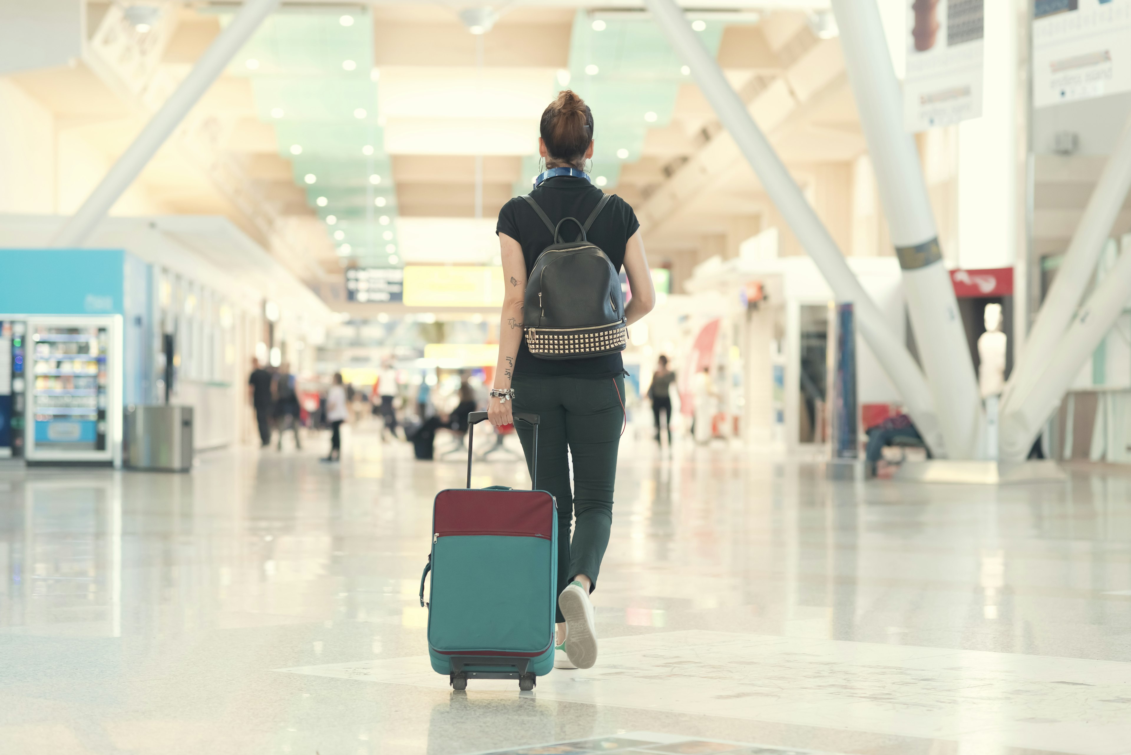 A woman is dragging her luggage through the airport