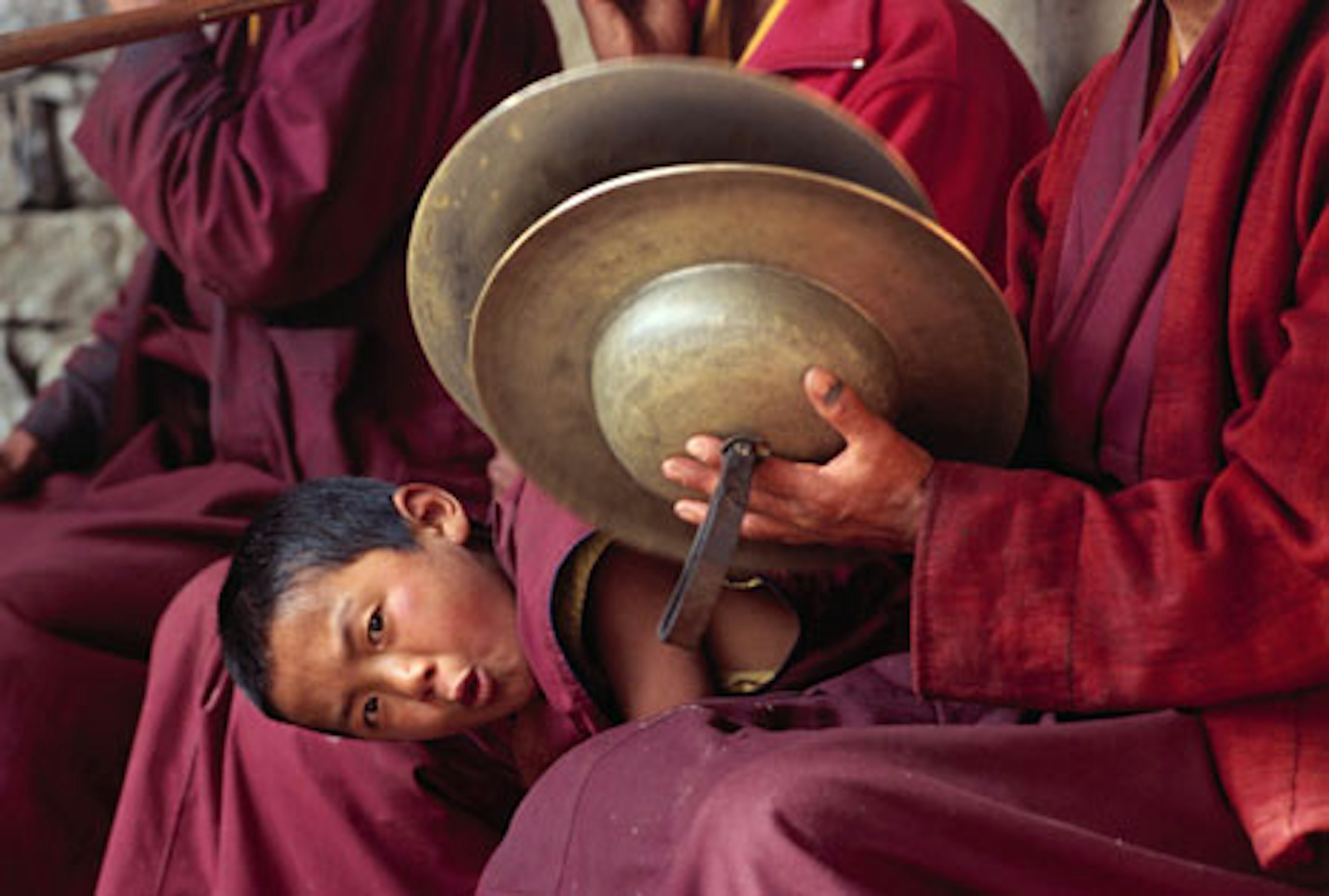 Young monk peering out from group at Tengboche Monastery. Image by Richard I'Anson.