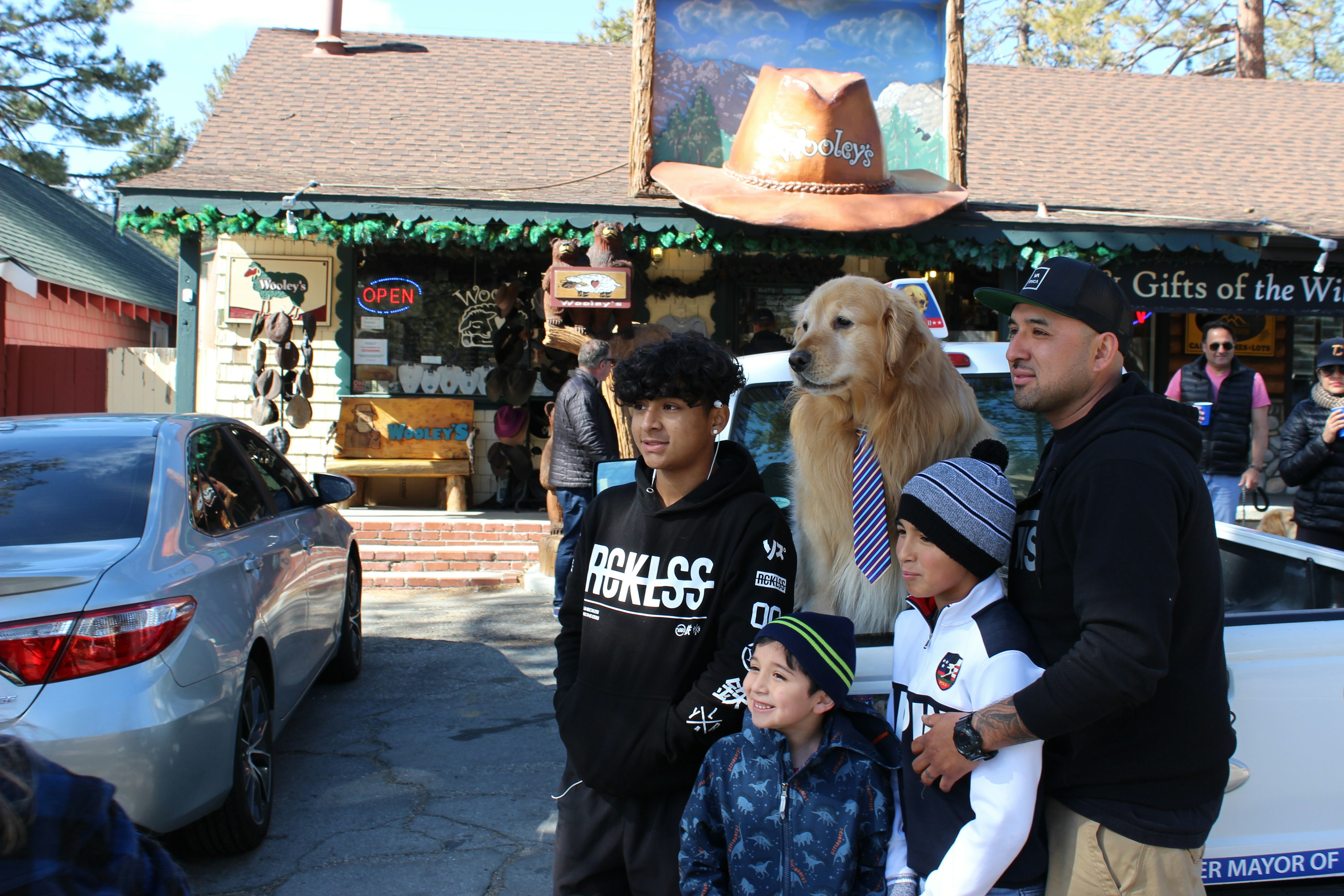 A family takes a photo with a golden retreiver