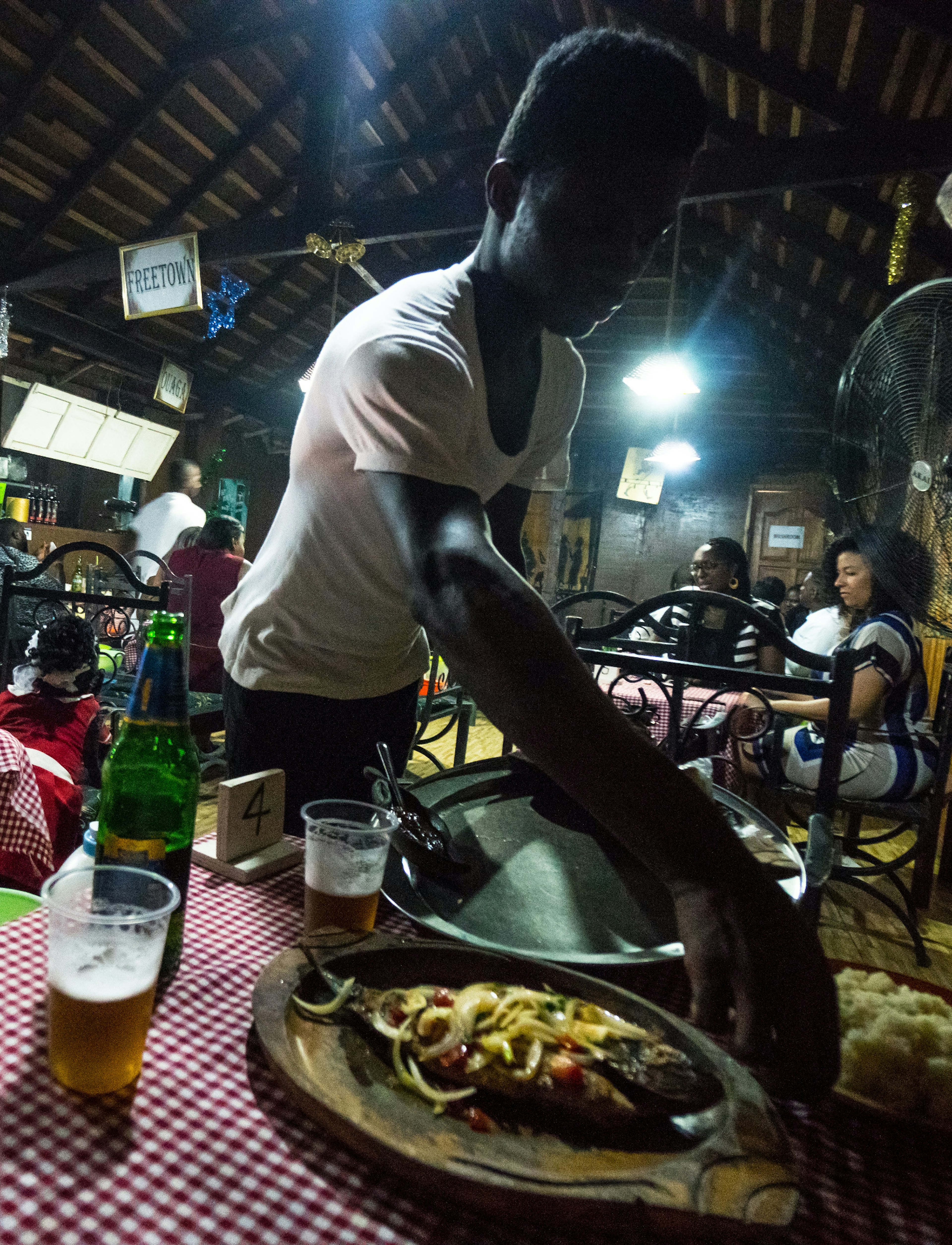 The dark and atmospheric confines of Chez Clarisse Mama Africa, a Ivorian restaurant known for its fried tilapia