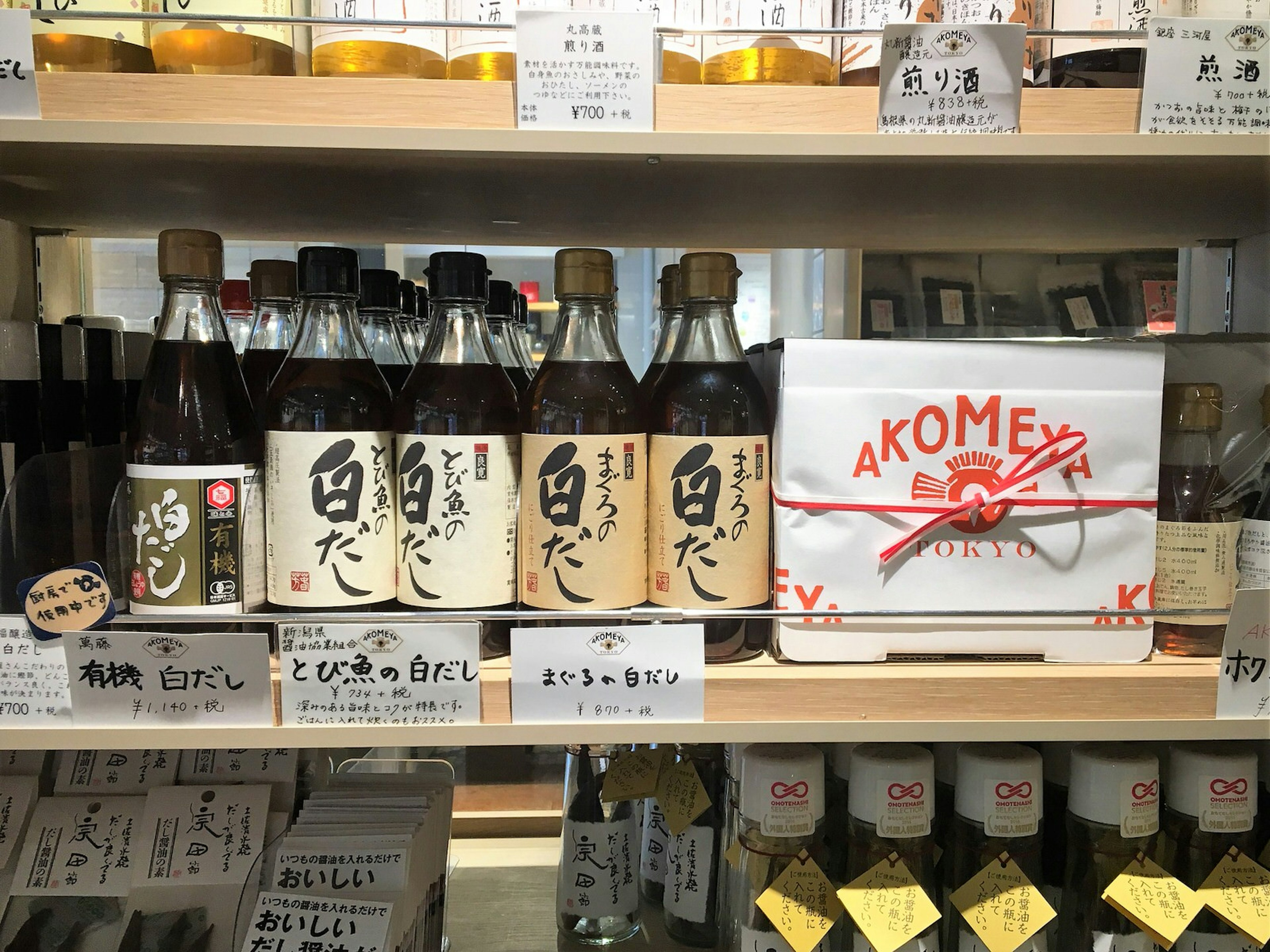 A shelf lined with bottles of soy sauce and a gift box of sauces with the Akomeya logo © Rebecca Milner / Lonely Planet