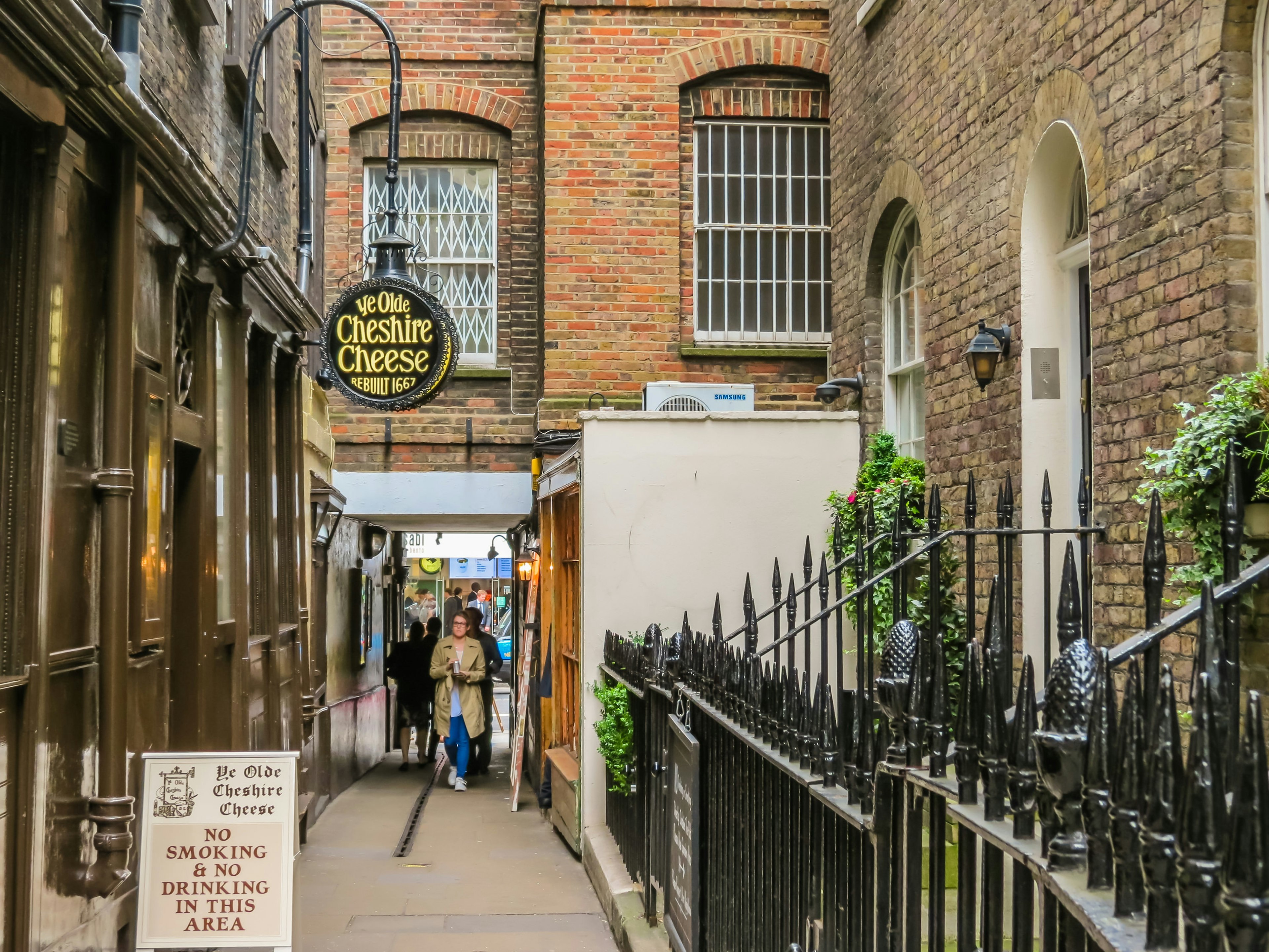 A historic alleyway lined in brick, just off a modern street