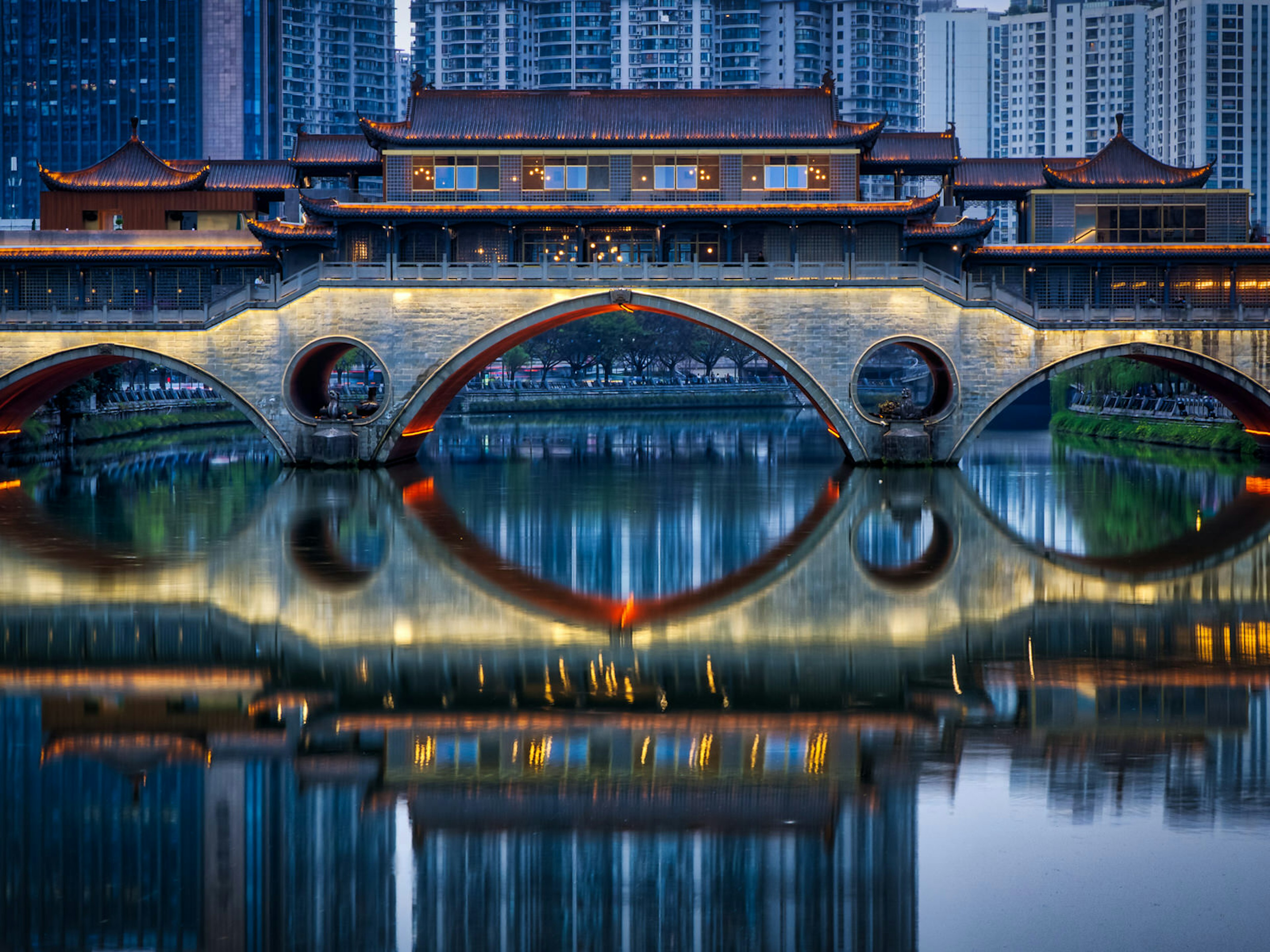 A covered Chinese bridge with modern buildings in the background. Chengdu's Anshun Bridge was mentioned by Marco Polo in his 13th century writings about China ? Nick Wonnell / Shutterstock