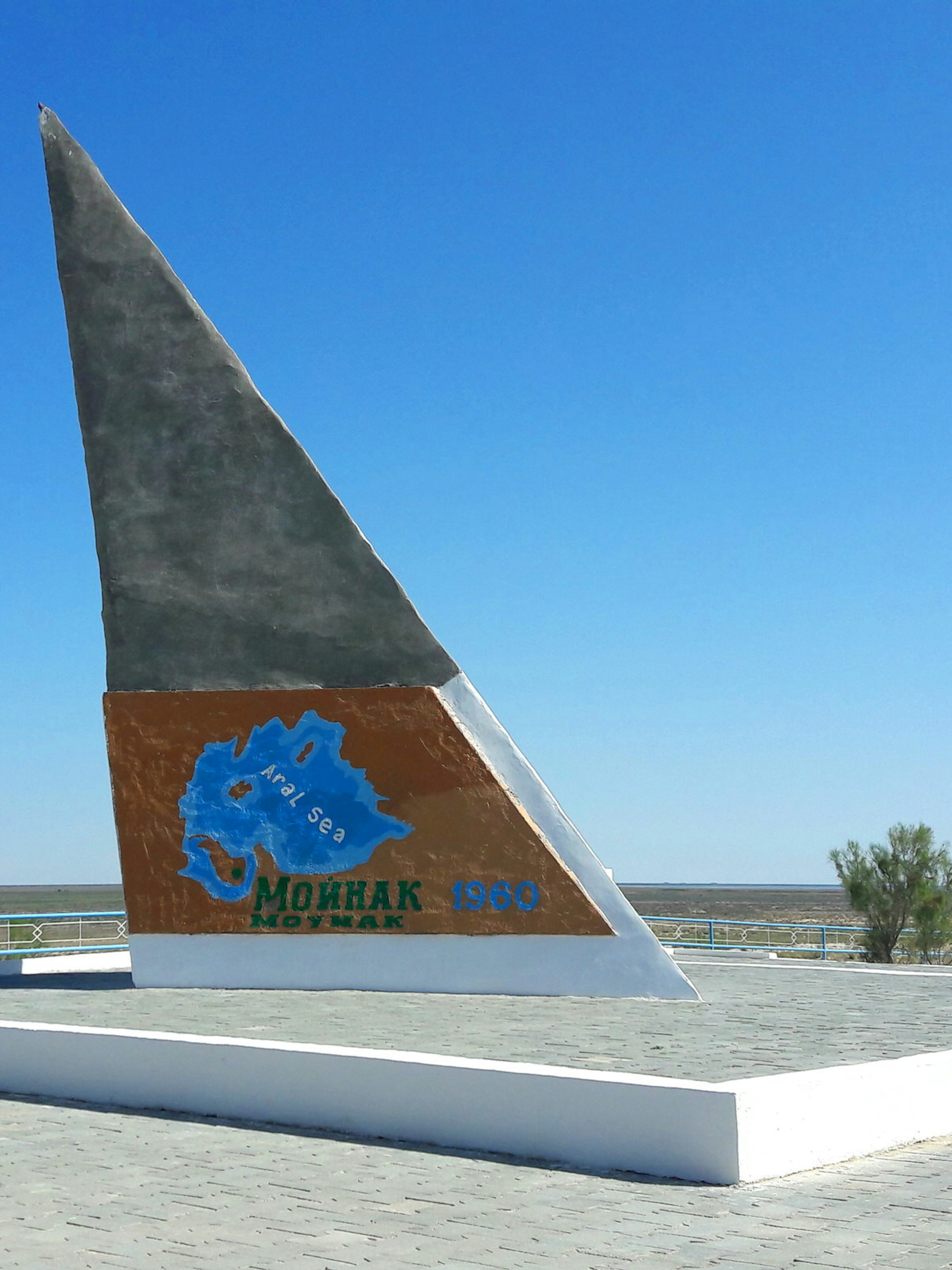 A triangular concrete monument stands in the desert.