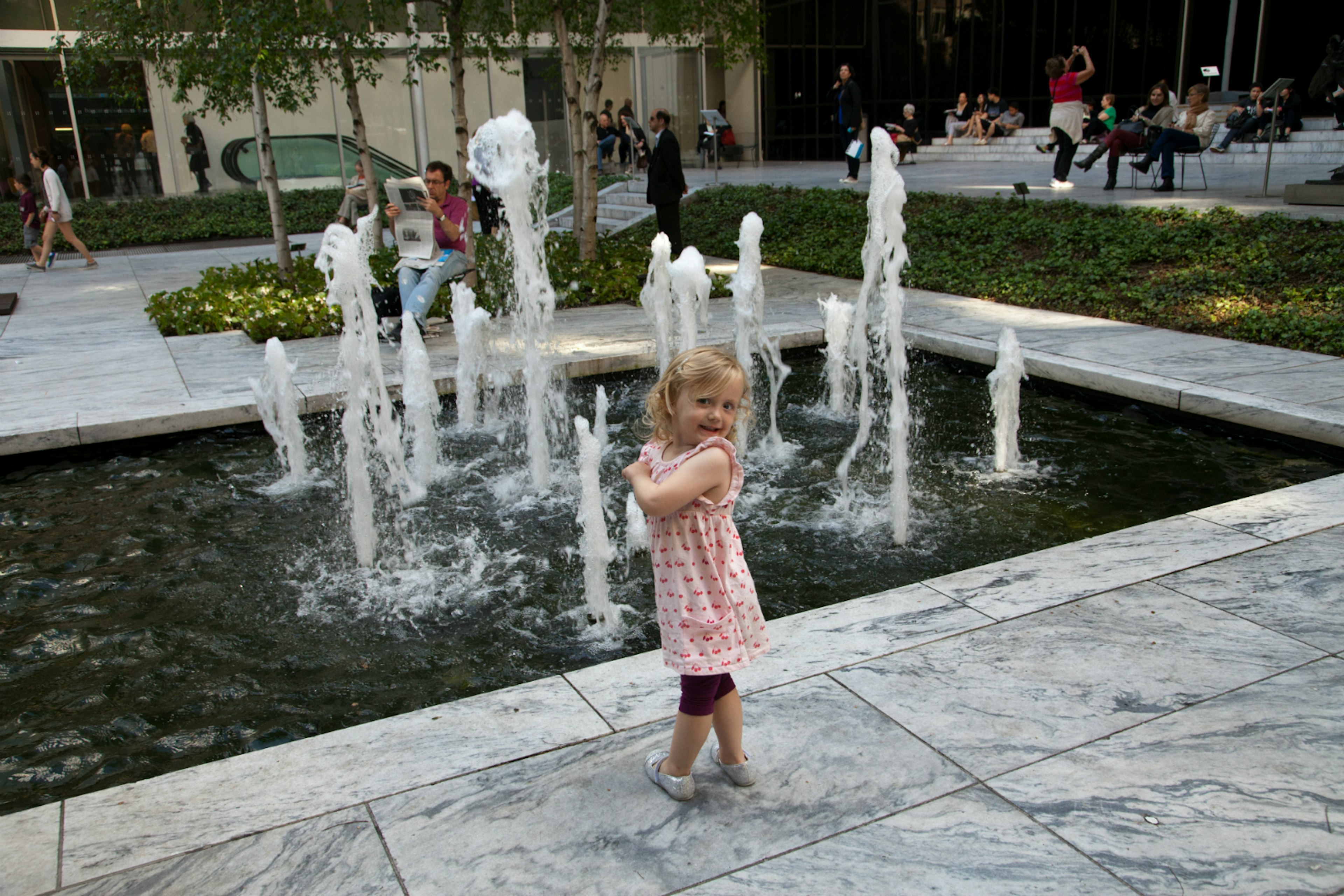 A young girl enjoys the fountain in MoMA's grounds, NYC © Christine Knight / Lonely Planet