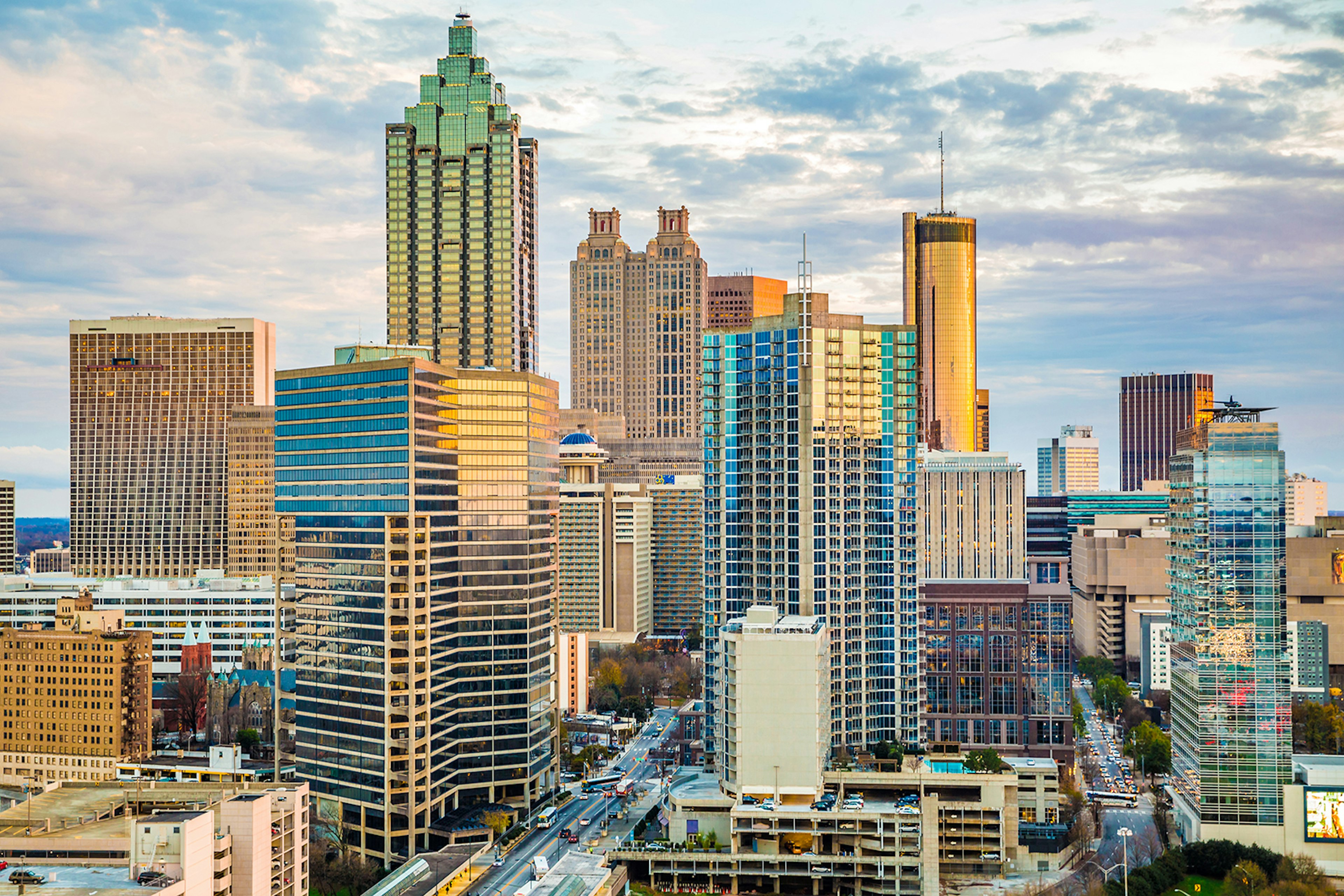 The many skyscrapers of the Atlanta skyline, as seen at sunset with a rosy glow cast across them