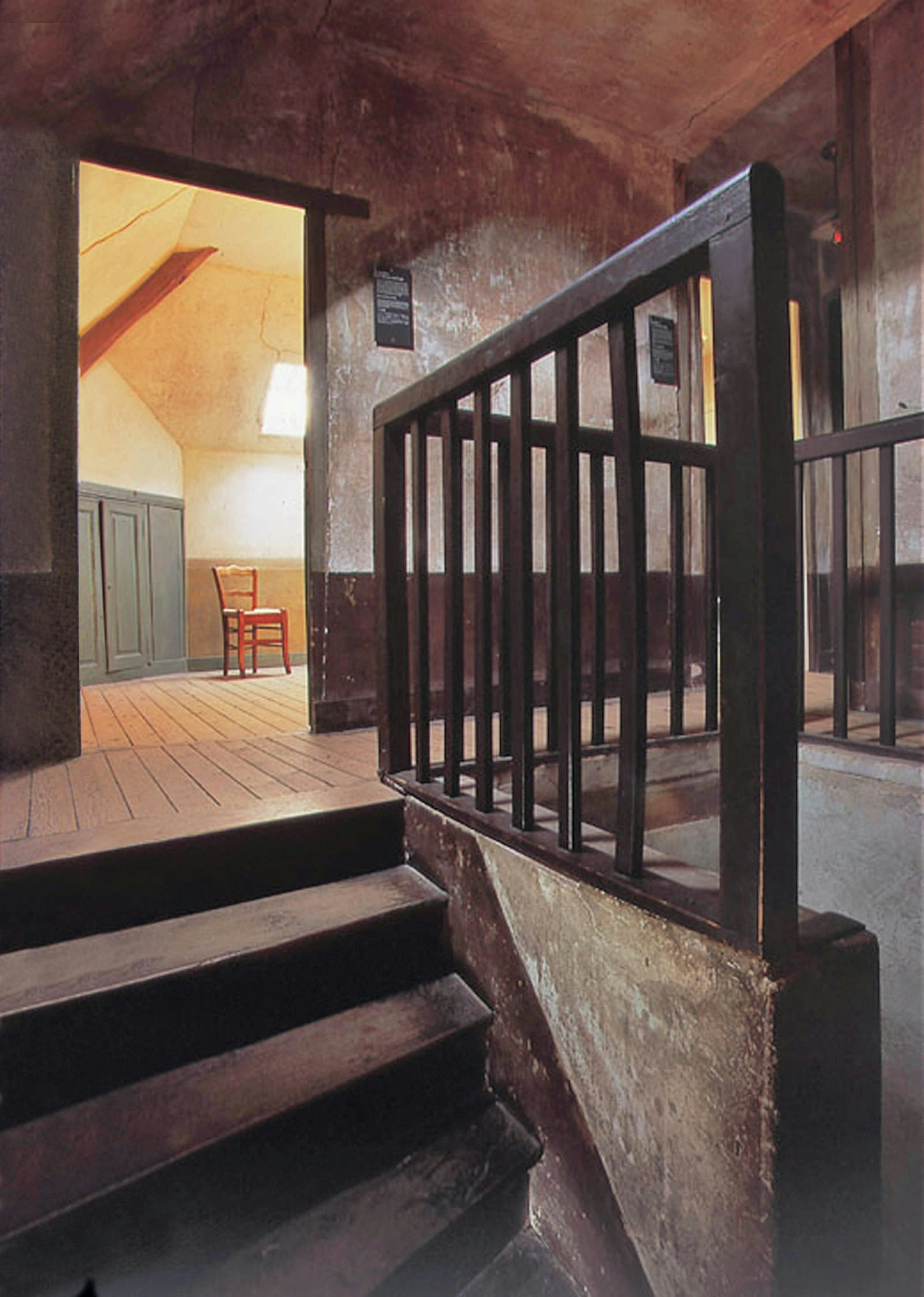 A chair and a cupboard peek from the simple room where Van Gogh stayed during his time at Auvers-sur-Oise © Institut Van Gogh