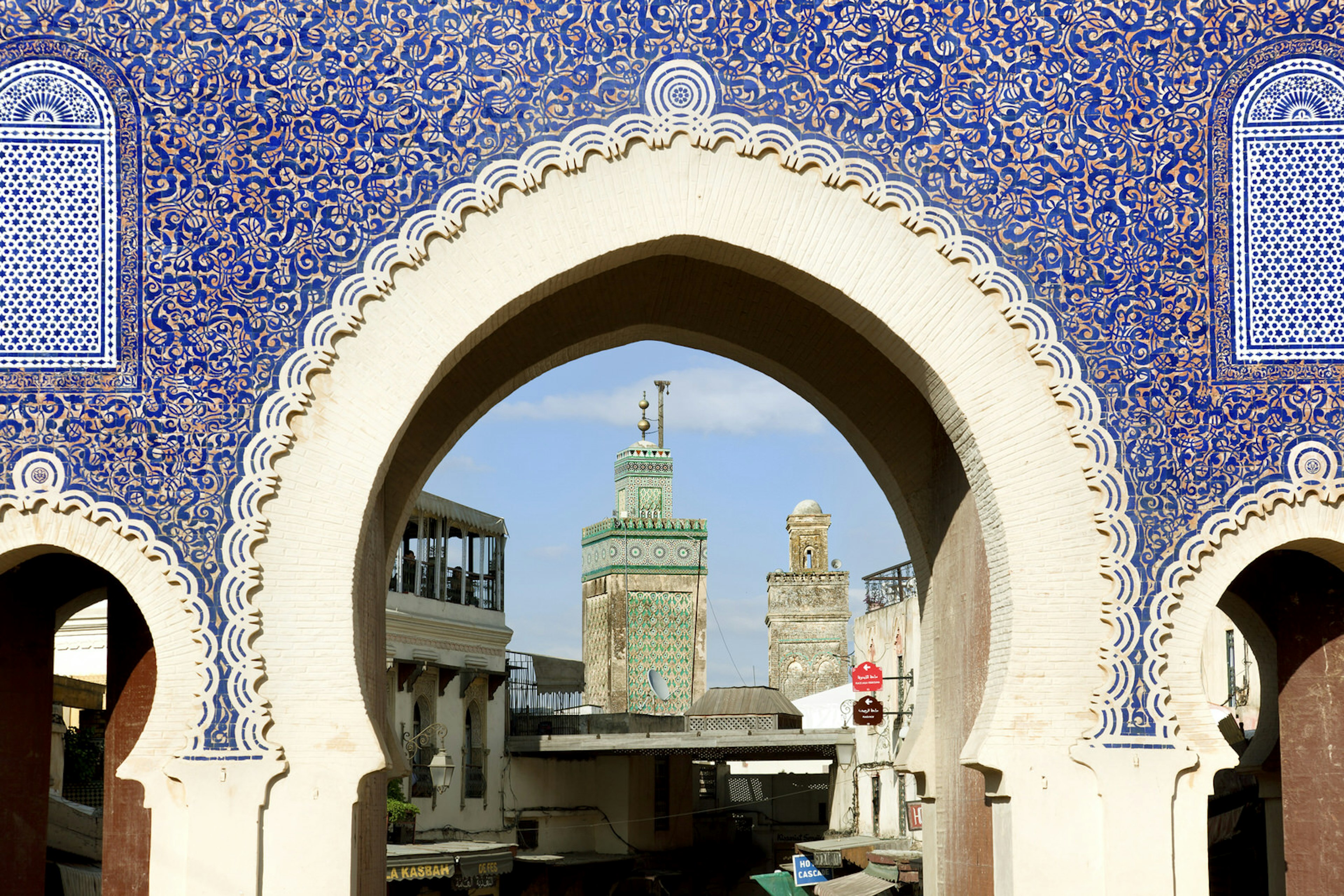 The Bab Bou Jeloud is a recent addition to Fes El Bali, having been built around 1913. The Medersa Bou Inania minaret is framed by this impressive gateway into the Medina
497015885
Bab Boujeloud, Travel, Tourism, Medina District, Glazed, Arabic Script, Arabic Style, Souk, Minaret, Mosaic, Entrance, Tile, Islam, Middle Eastern Ethnicity, Arch, Medieval, Blue, Cultures, Famous Place, Architecture, Travel Destinations, Fez - Morocco, Morocco, North Africa, Africa, Day, Mosque, Gate, Entrance, North African Culture