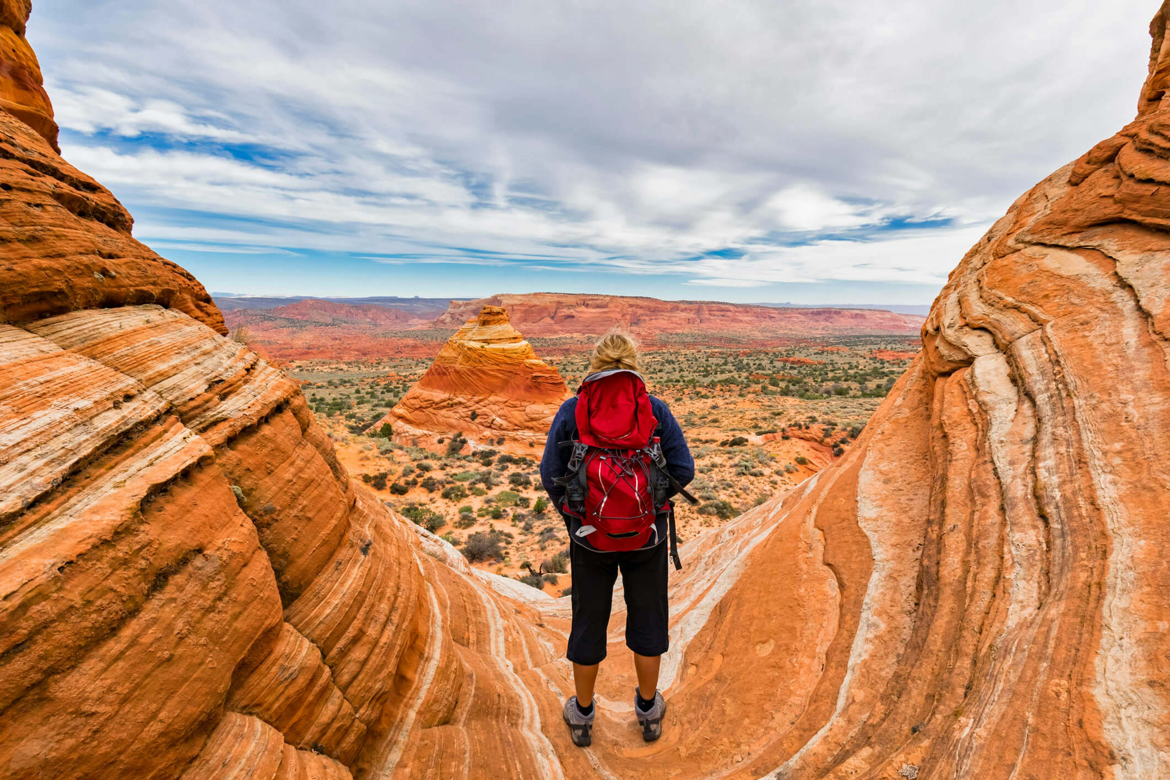 A backpacker standing on rocks and gazing out on the view