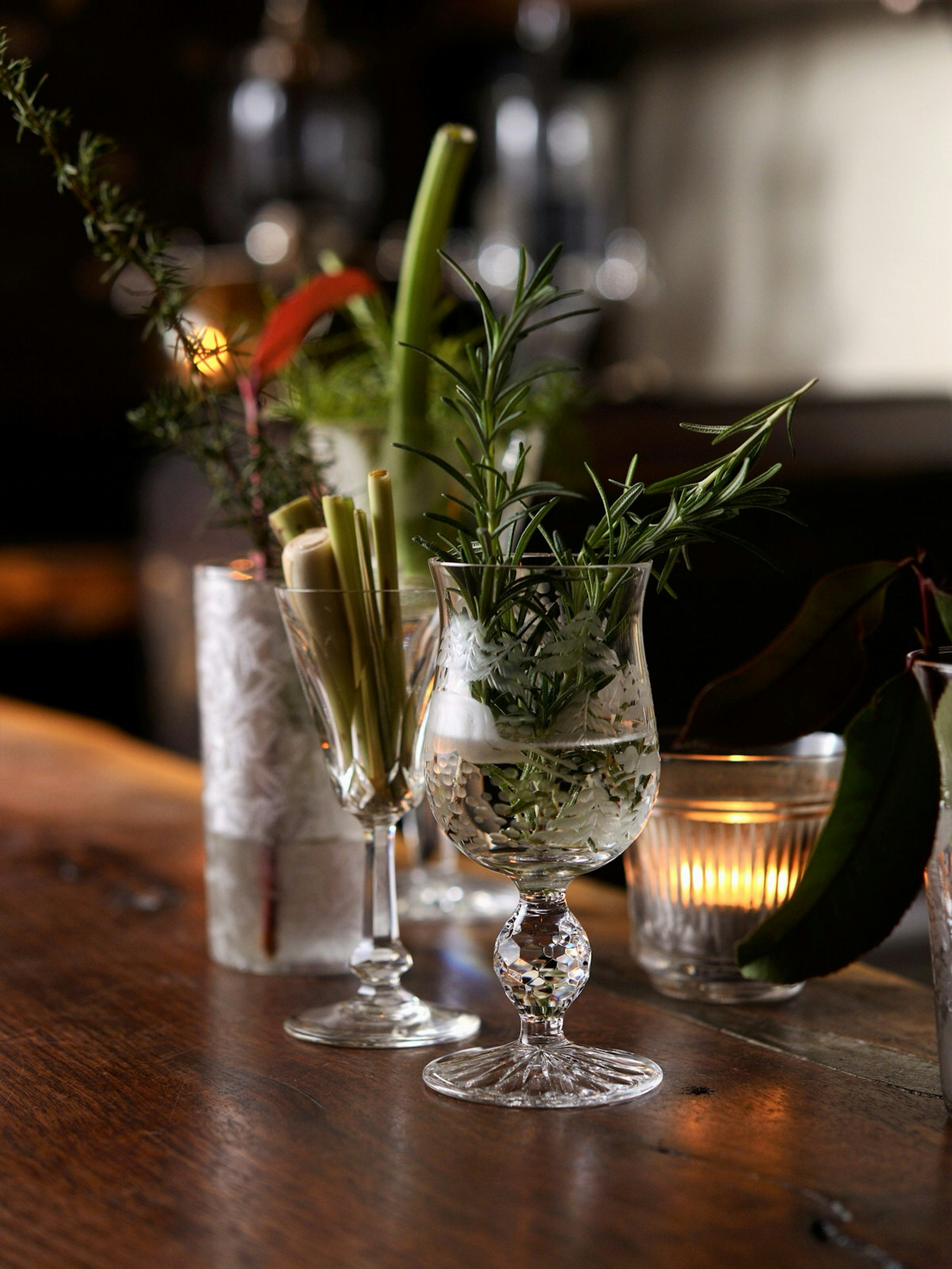 View of two cocktail glasses filled with drink and stuffed with various herbs, on the bar counter at BenFiddich in Tokyo © Junichi Miyazaki / Lonely Planet