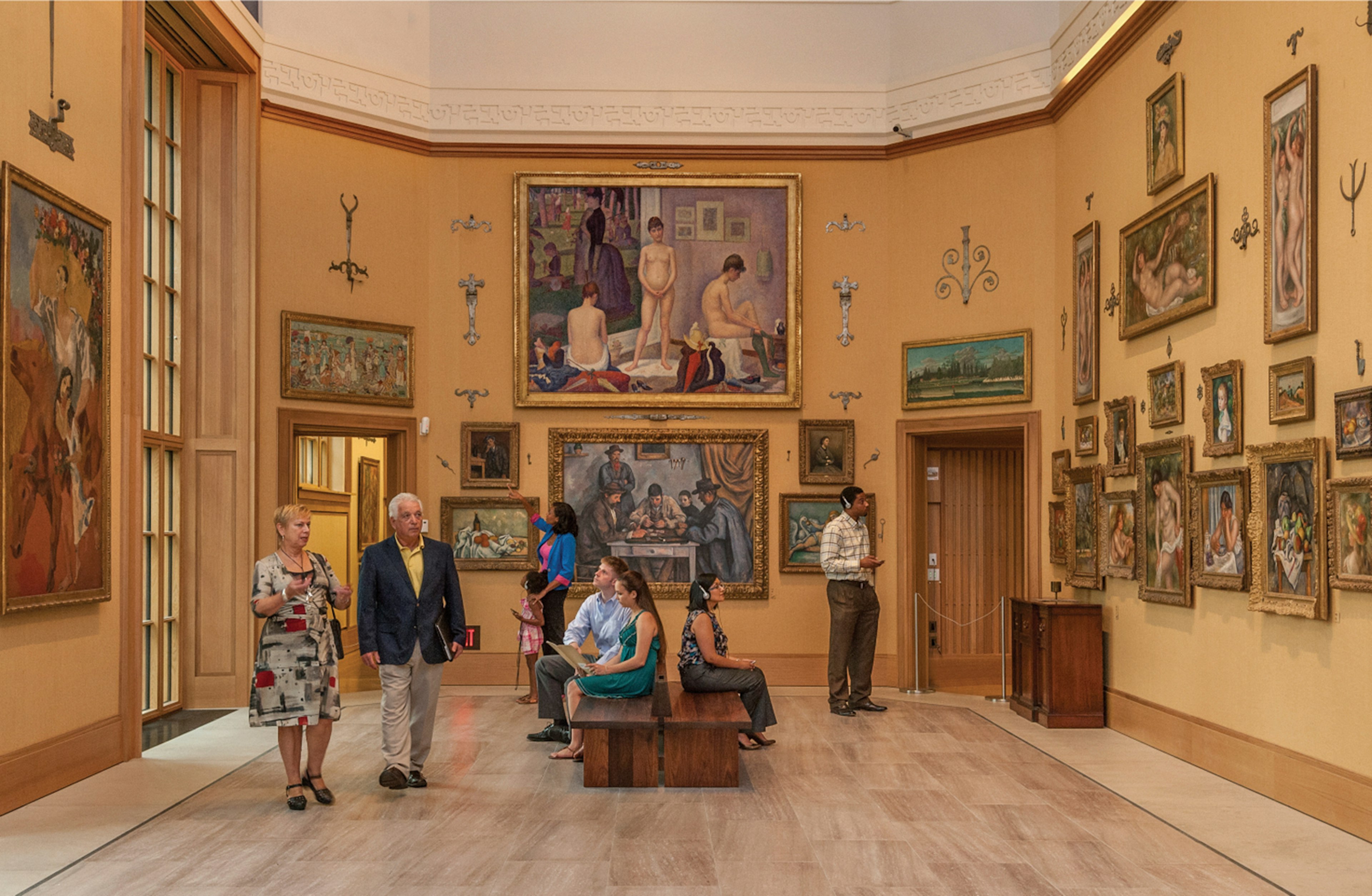 handful of museum patrons mill around a large, high-ceilinged room with late 19th-century masterworks on the walls