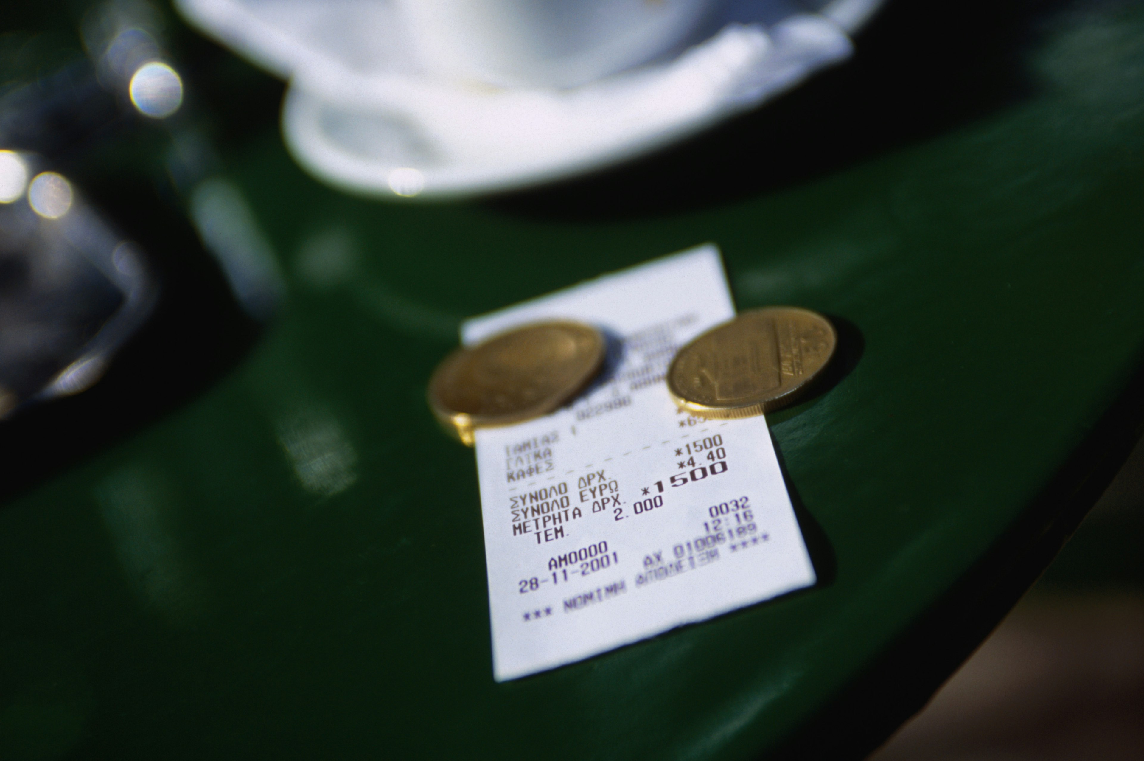 A bill and some coins on small outside tables