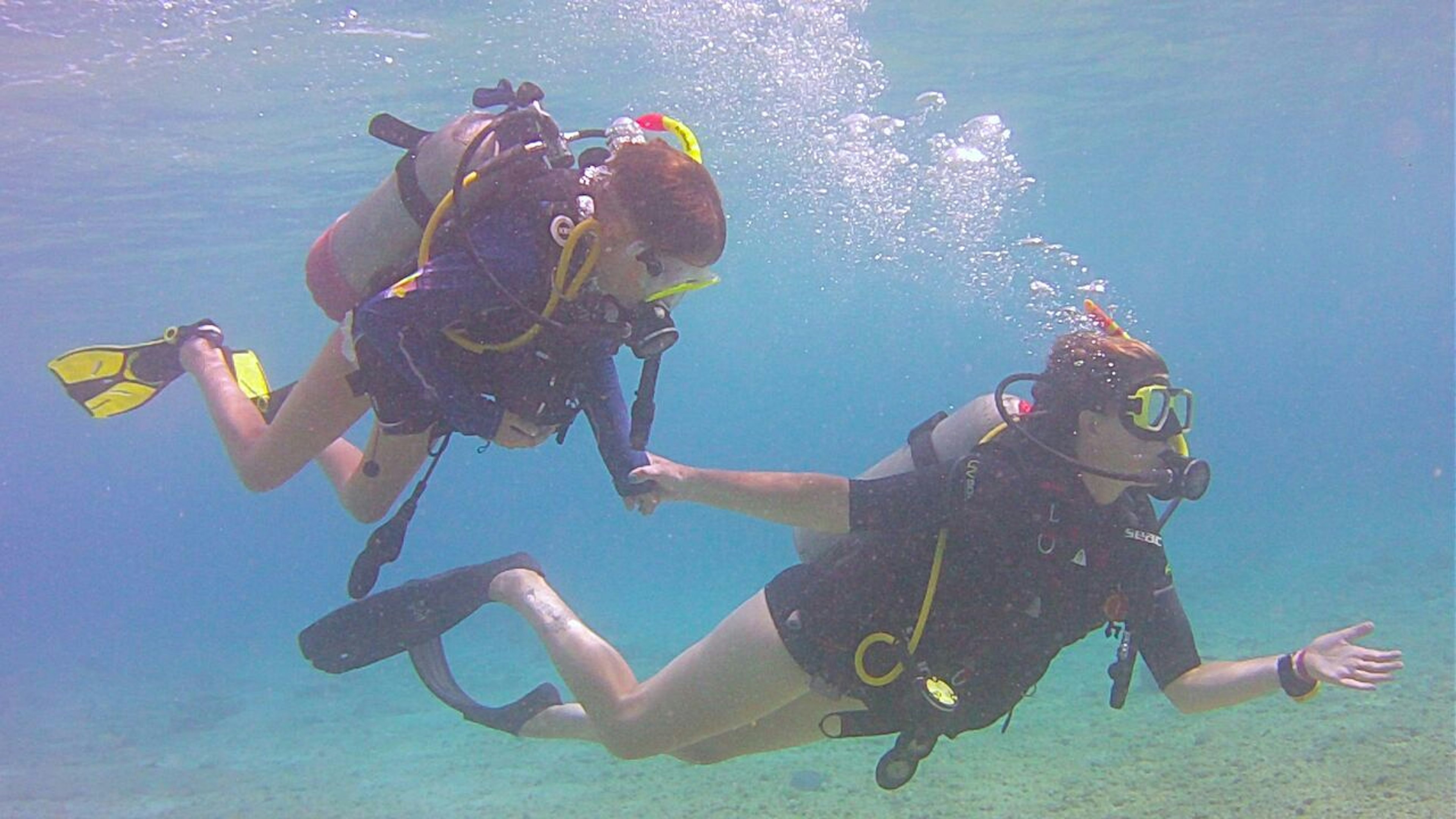 A mother and daughter hold hands while diving in Bonaire Ethan Gelber/Lonely Planet