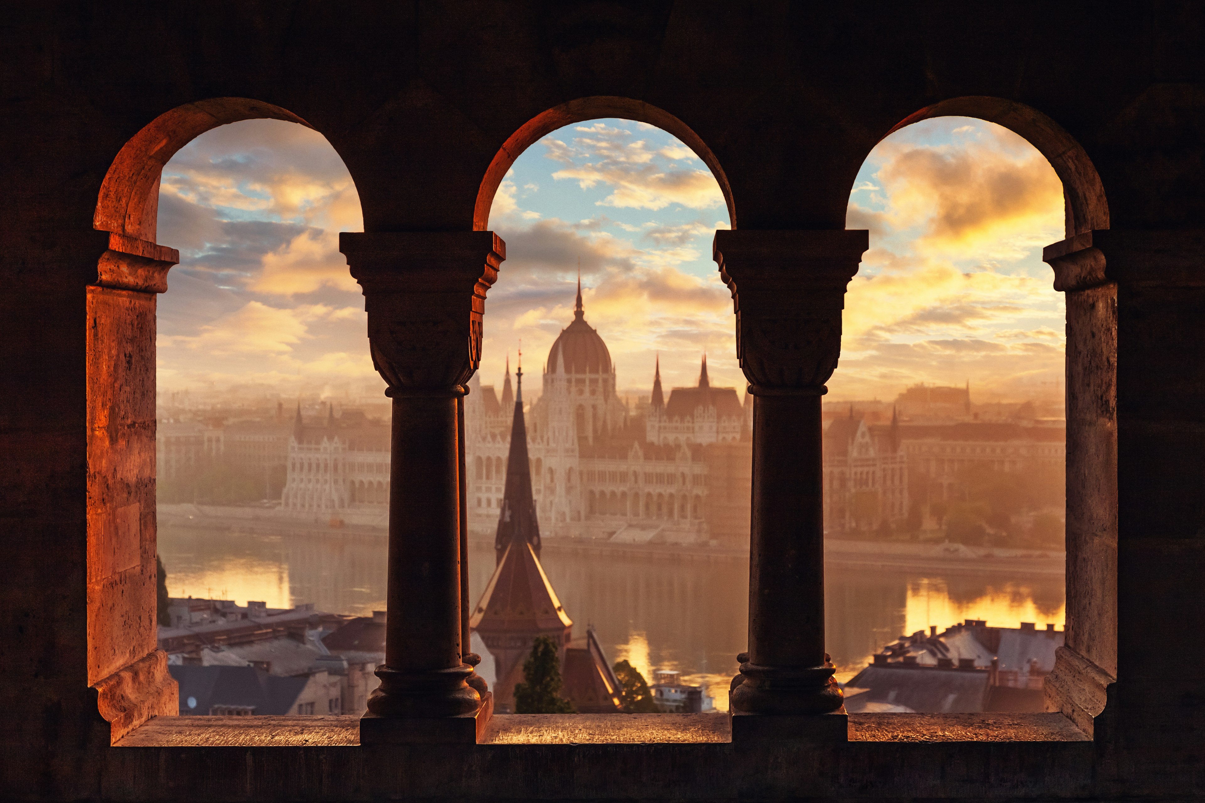 A view of a Hungardian Parliament building through columns.