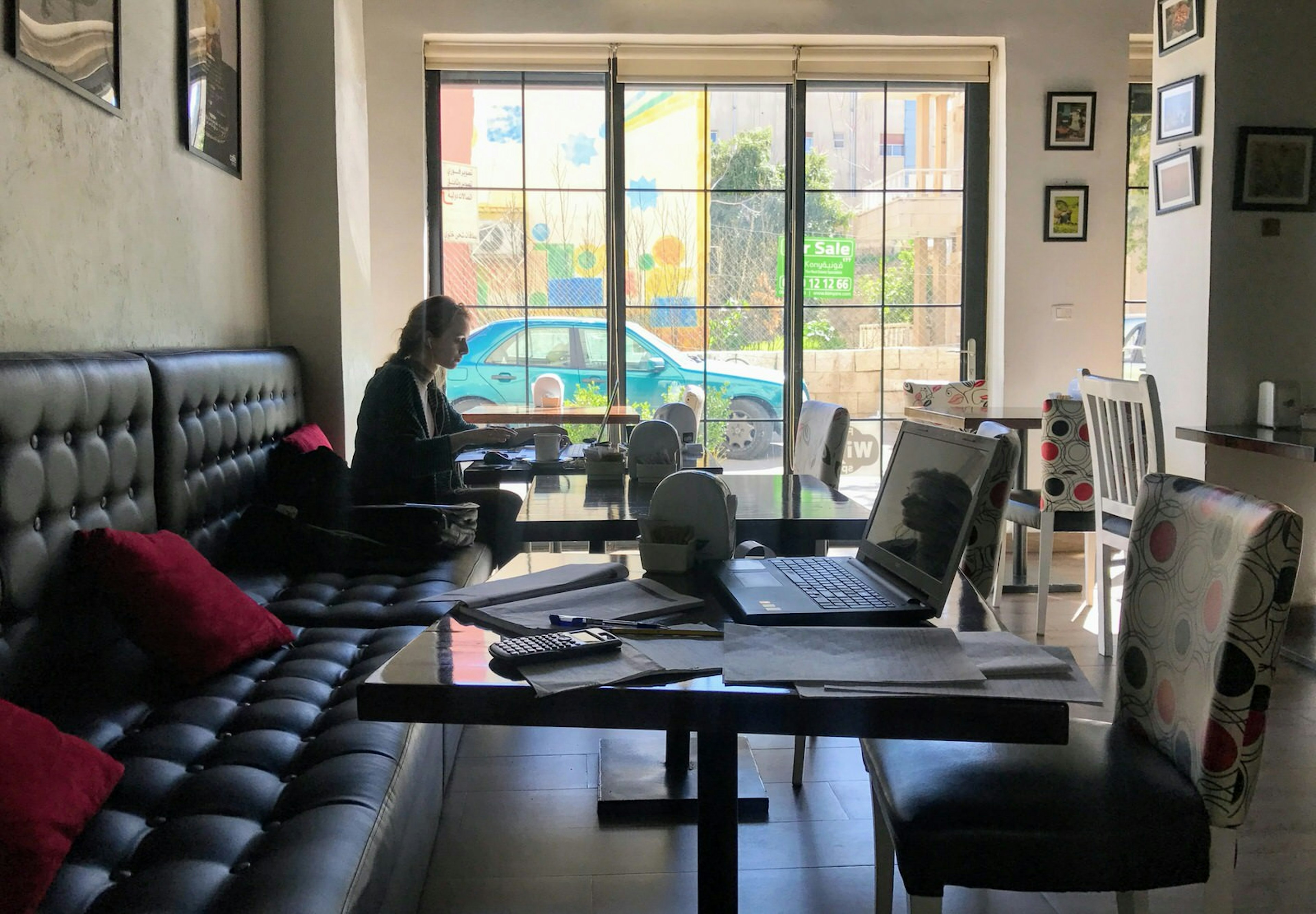 Woman working at a laptop in Caffe Strada, Rainbow Street, Amman, Jordan