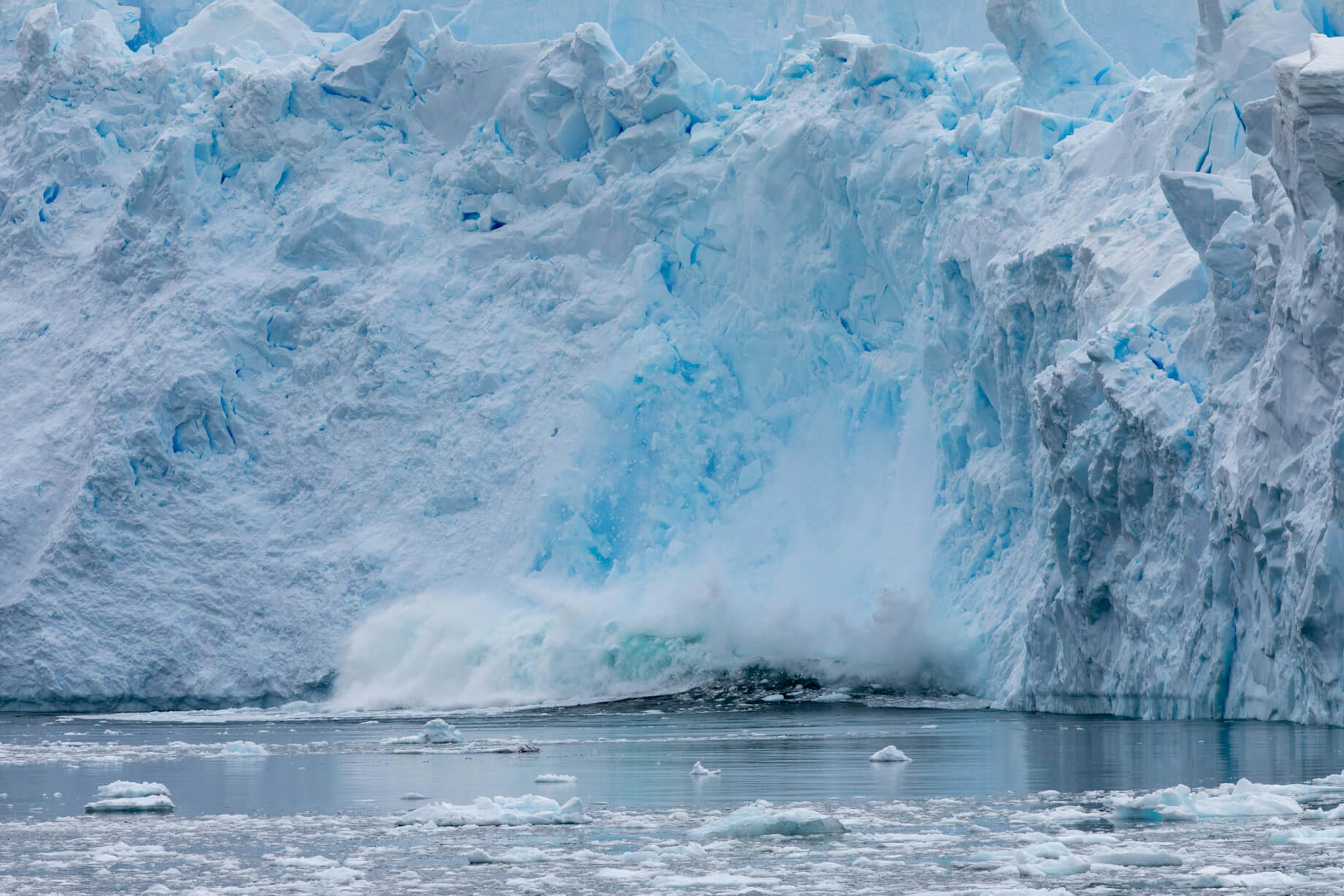 Chunks of ice break from a glacier into the sea.