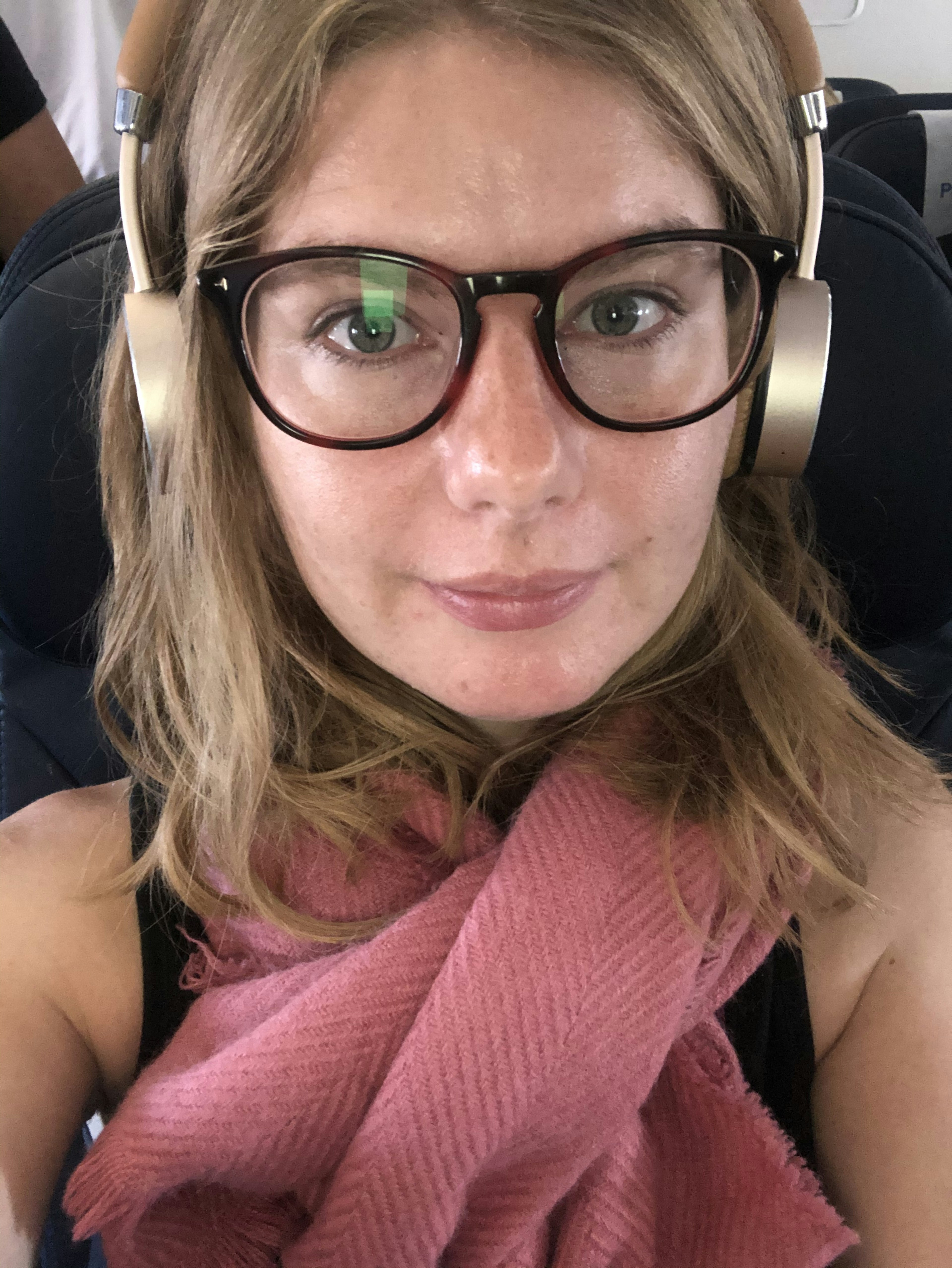 A woman wearing headphones on a flight