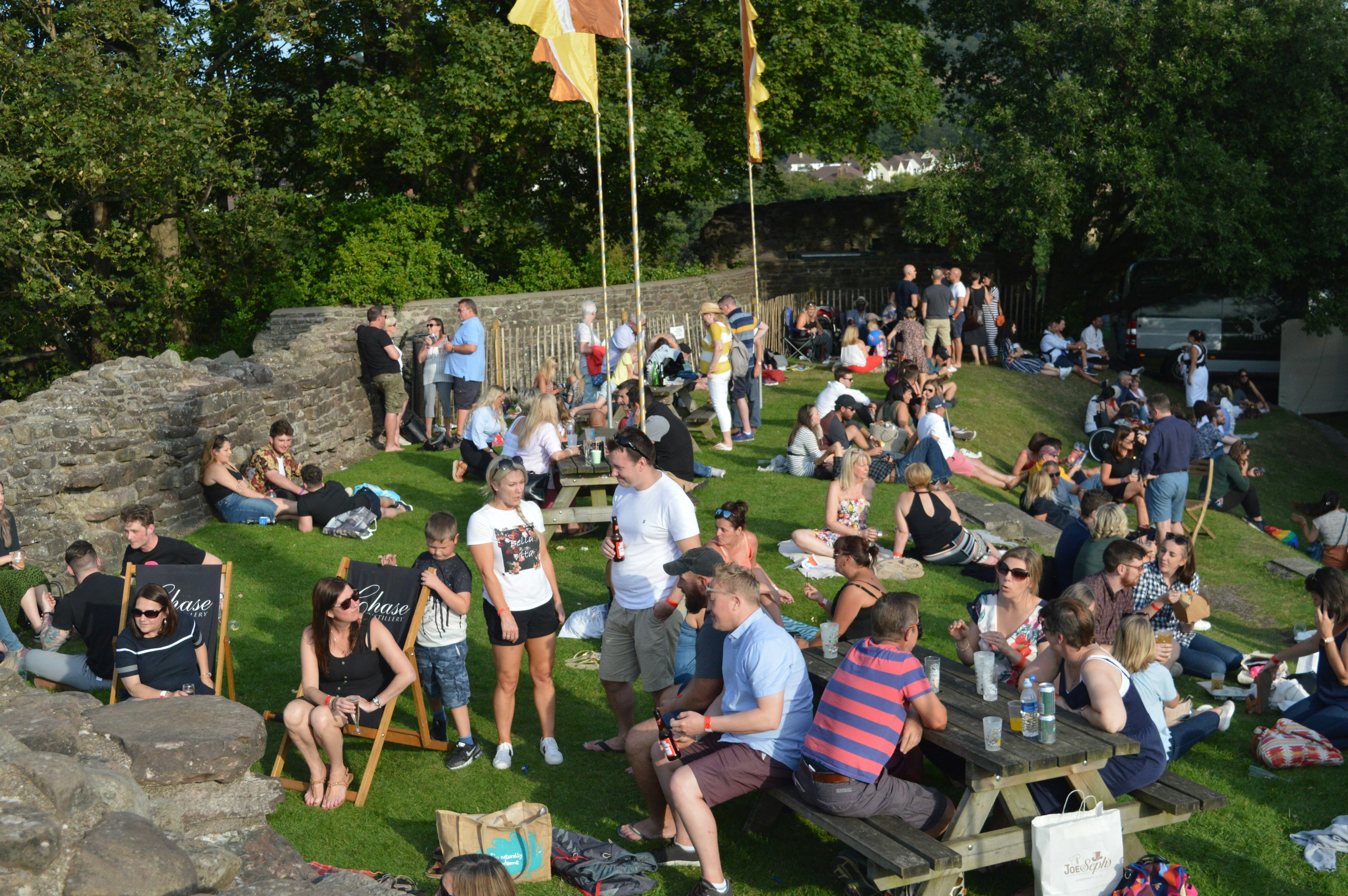 People standing and sitting on deckchairs in the sunshine during Abergavenny food festival