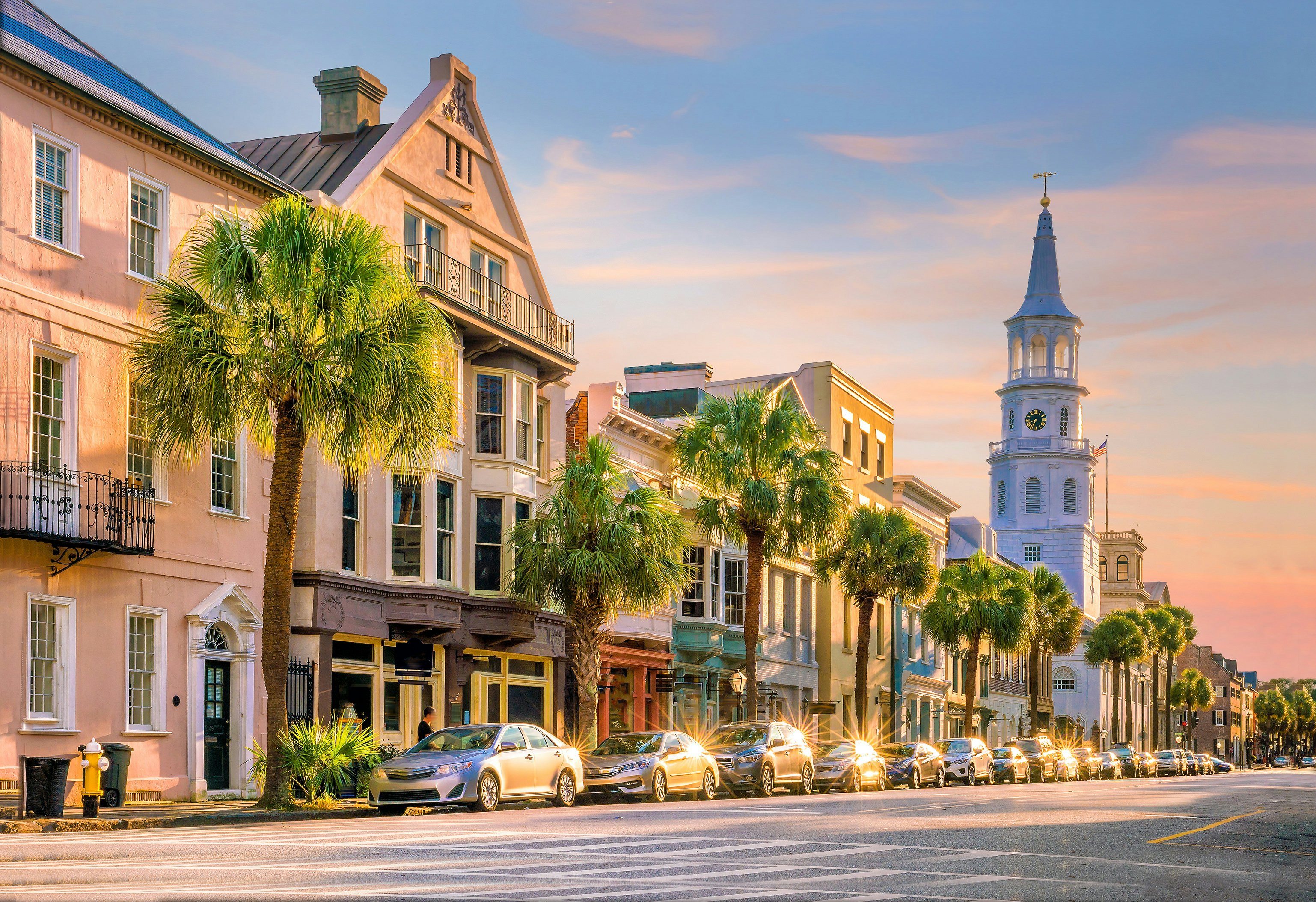 The setting sun reflects off parked cars in the historical downtown area of Charleston.