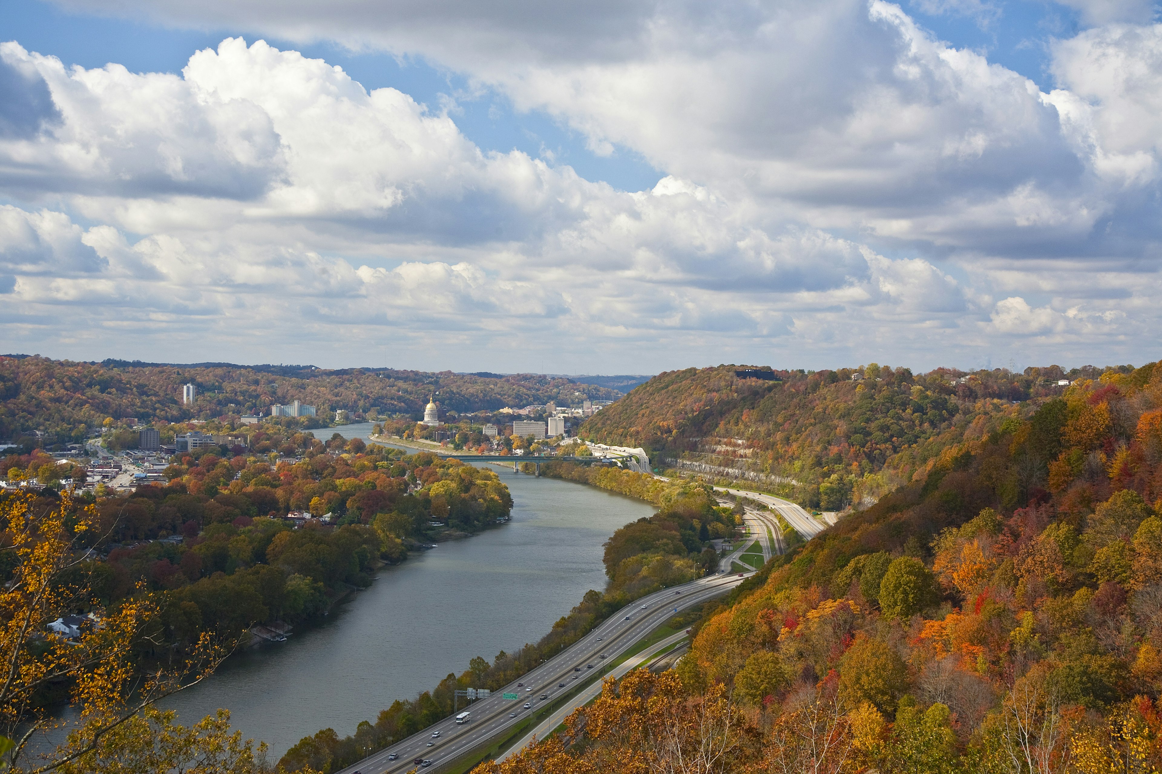 A view of downtown Charleston from a distance, shot from up the Kanawha River when the hollsides surrounding the highway and town are covered in bright autumn leaves