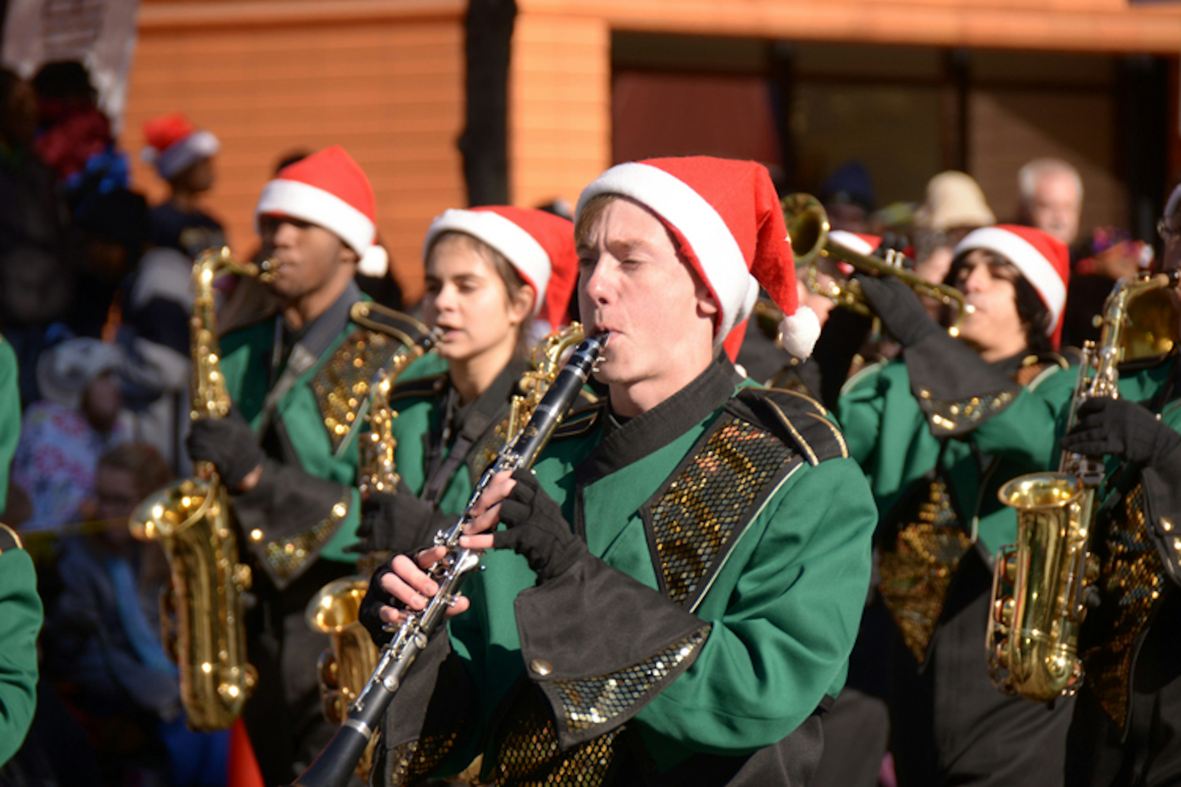 Marching band in Charlotte. A man plays the clarinet in a green uniform. America's best Thanksgiving Day parades