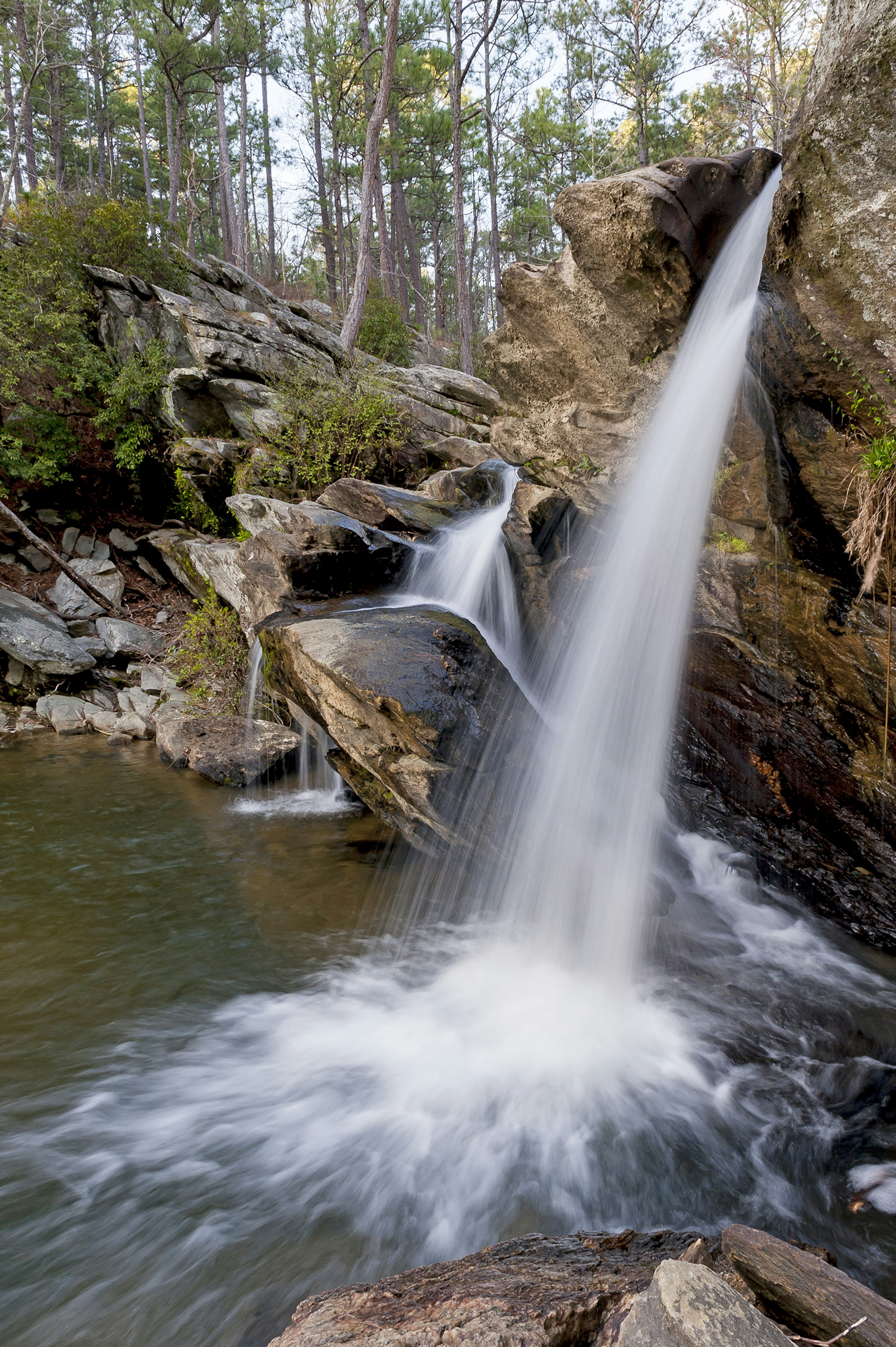 A small waterfall tumbles from a large rock into a pool in Talladega National Forest in Alabama