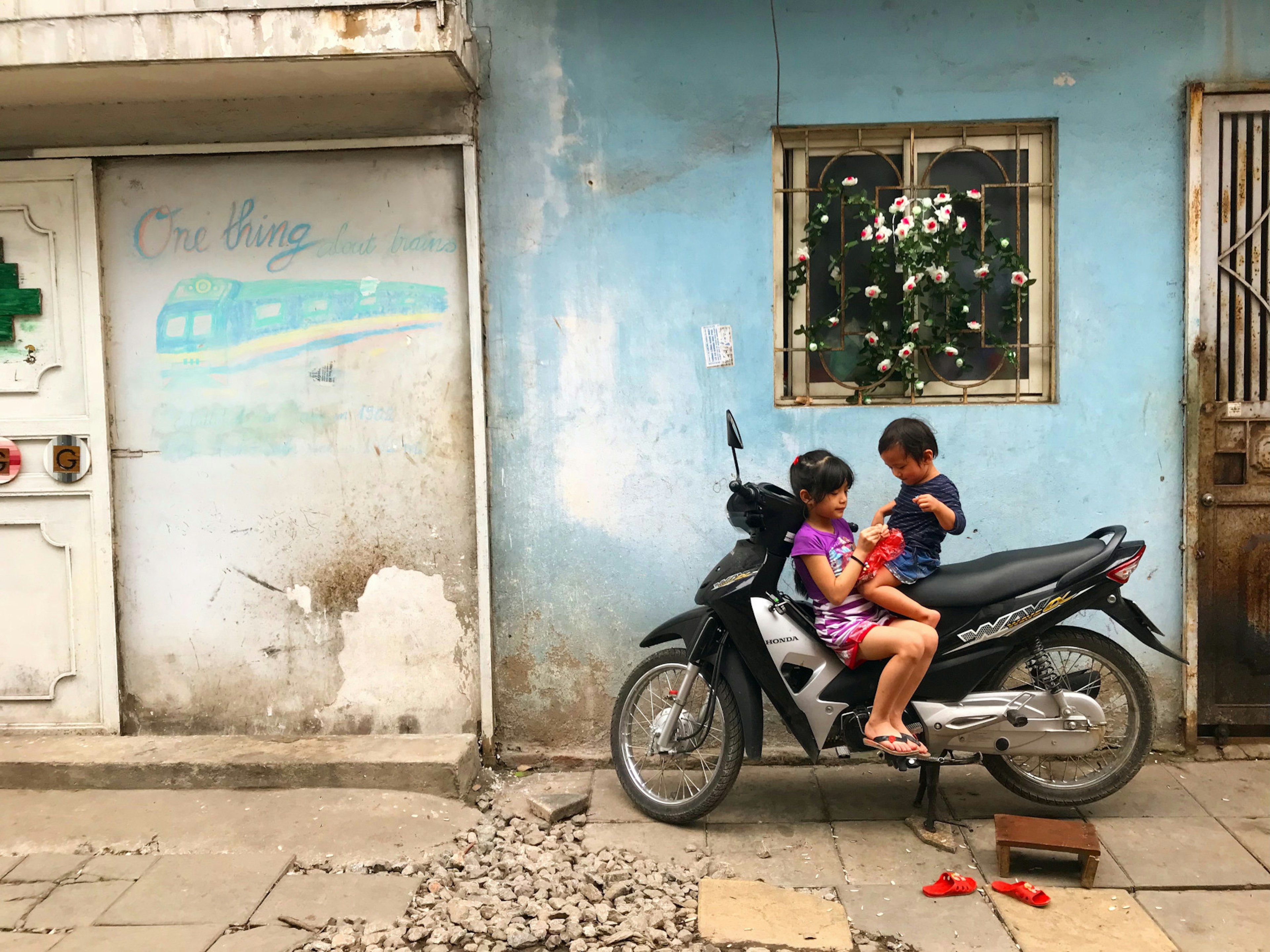 two children recline on a motorcycle