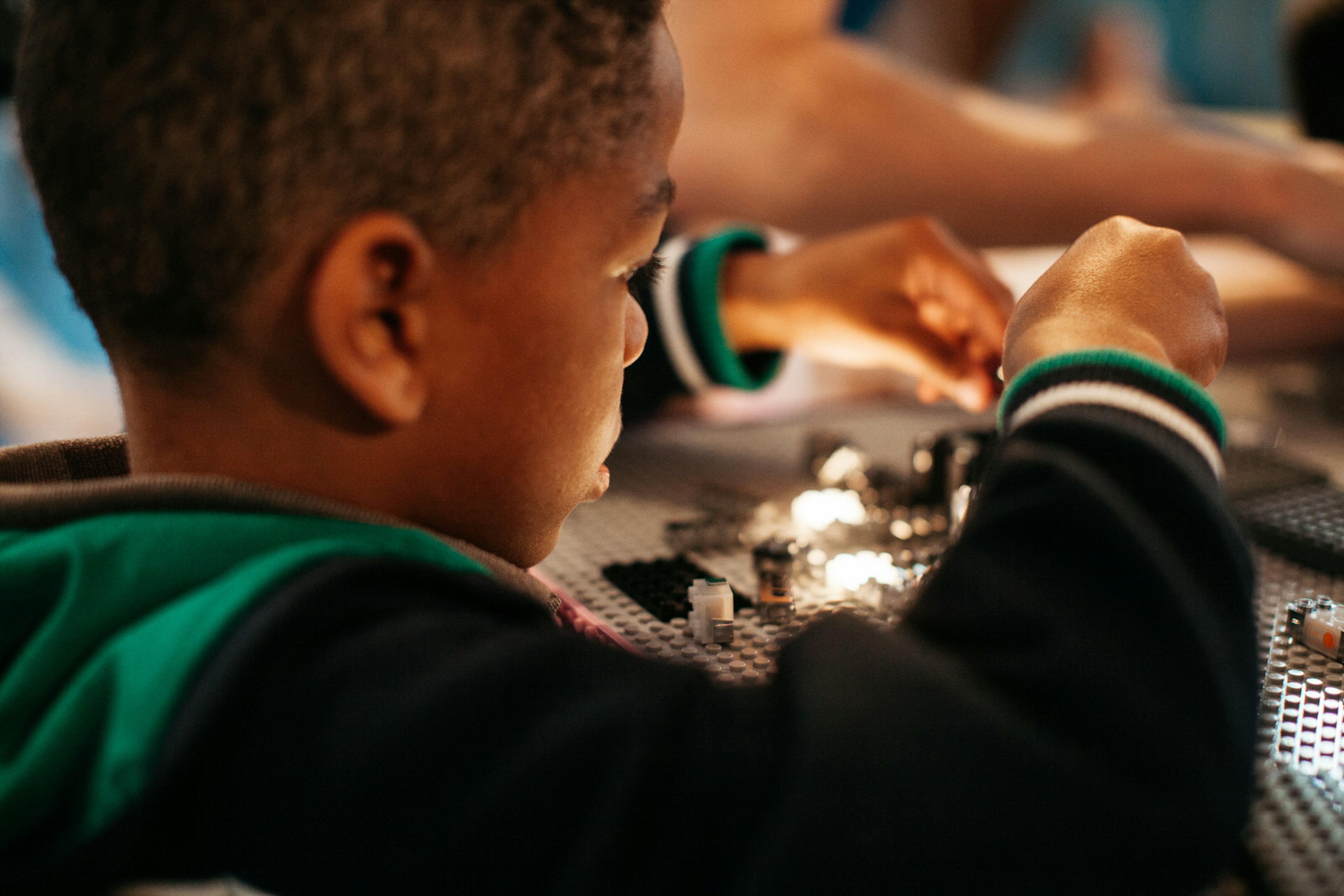 A close-up of a little boy playing with light-up Lego