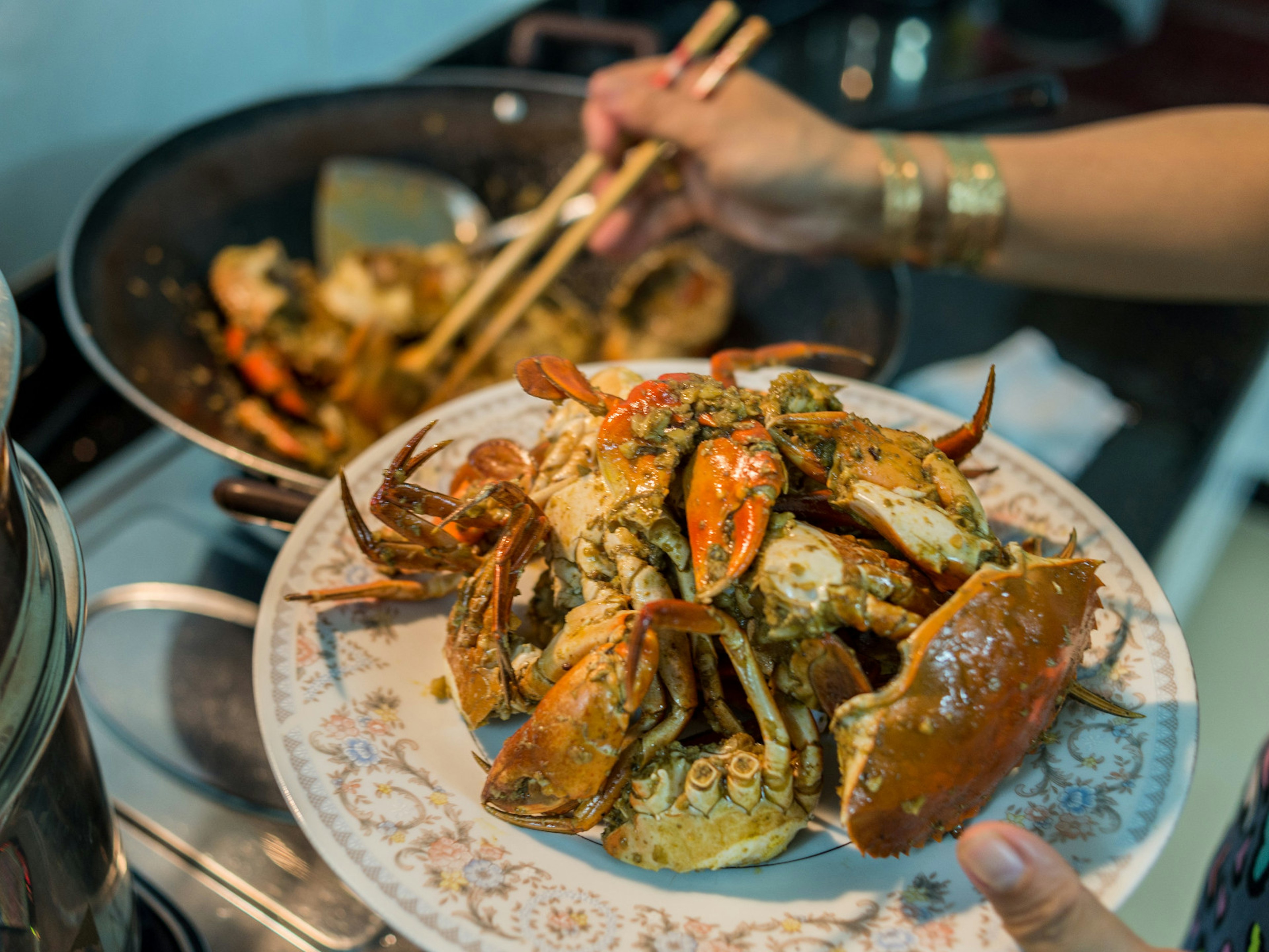 Woman preparing home-cooked chilly crab for dinner