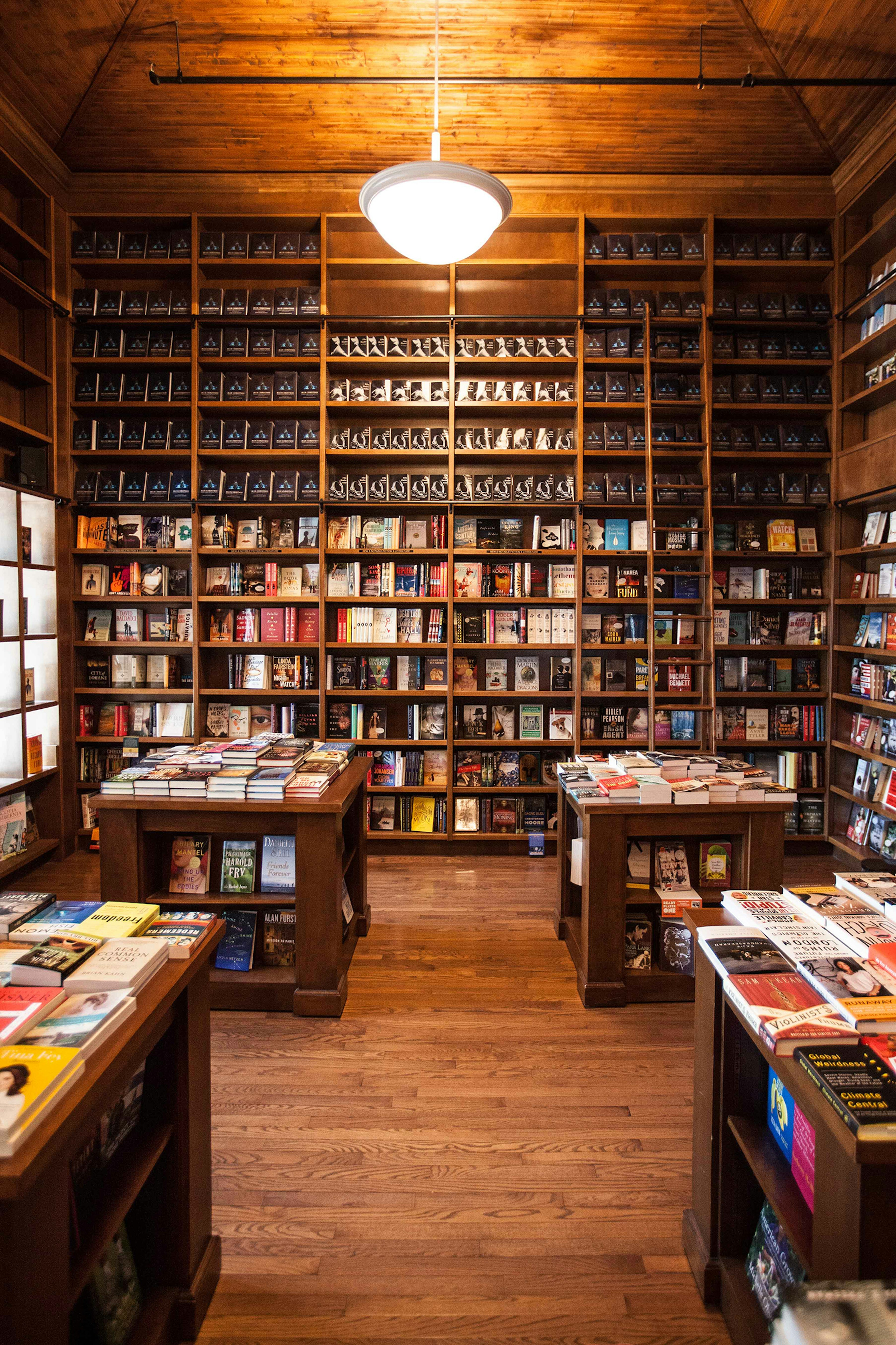 wall lined with mahogany bookshelves full of books from floor to ceiling in Books & Books in Miami