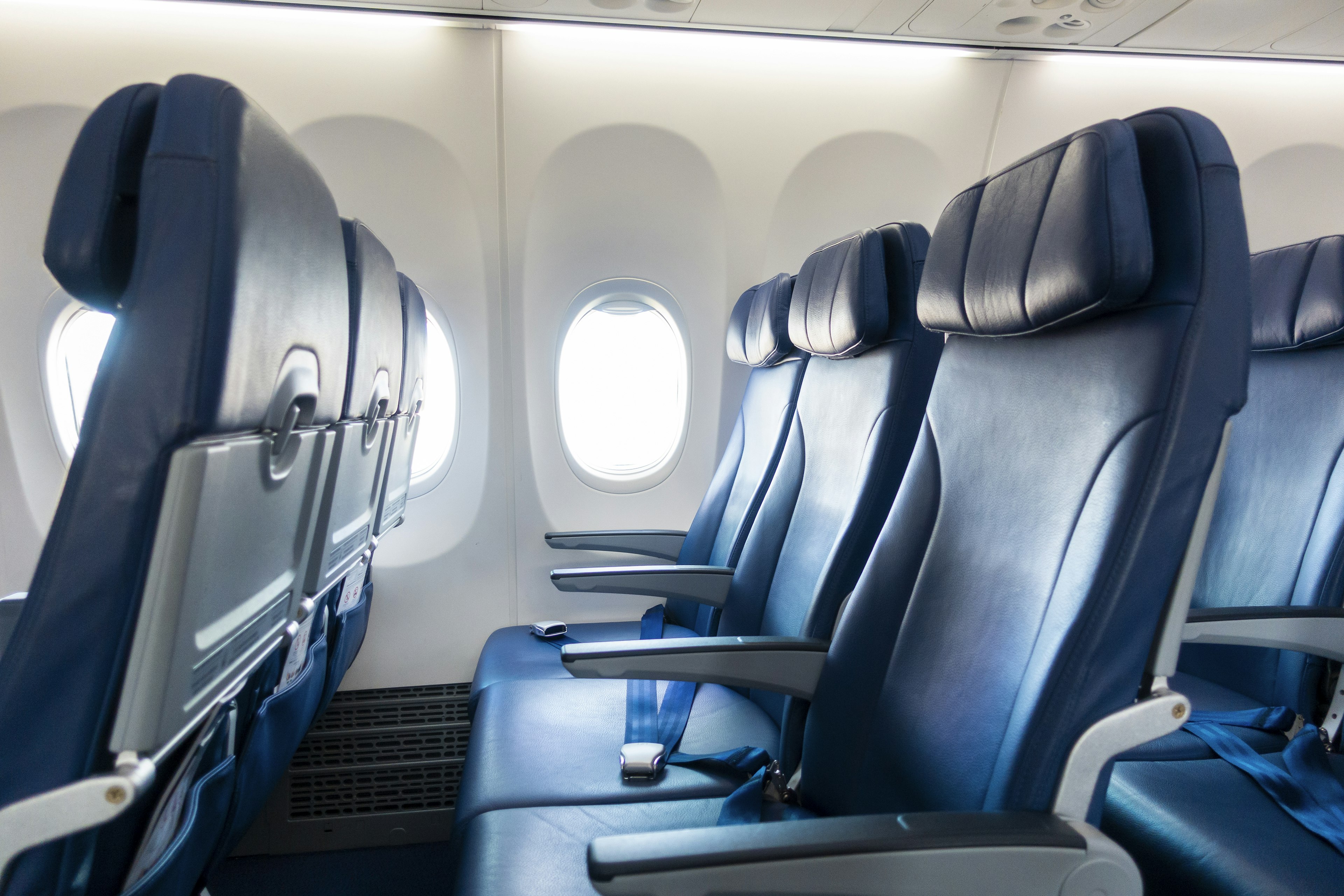 empty plane seats on a plane with an open window