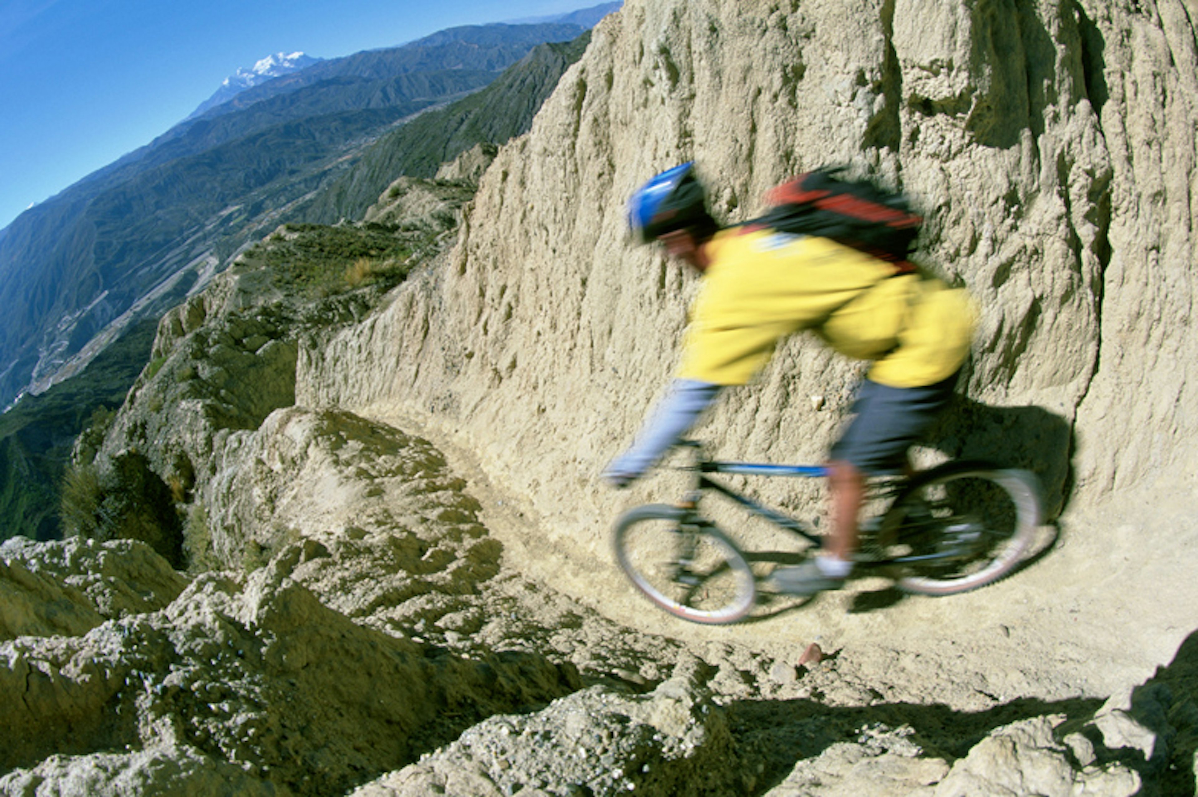 A mountain biker riding down a narrow trail, Altiplano, Bolivia. Image by Olivier Renck / Aurora / Getty Images.