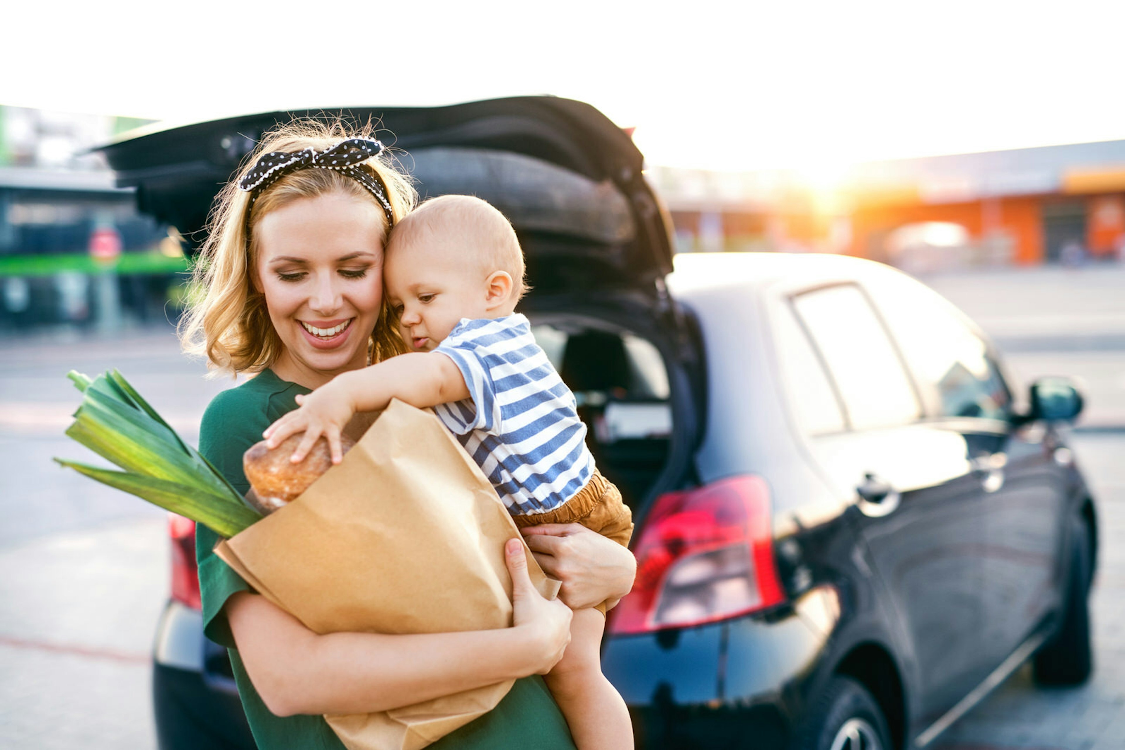 Young mother with baby boy in front of a supermarket.; Shutterstock ID 739697995; Your name (First / Last): Emma Sparks; GL account no.: 61025; Netsuite department name: Online Editorial; Full Product or Project name including edition: Road trip with kids article