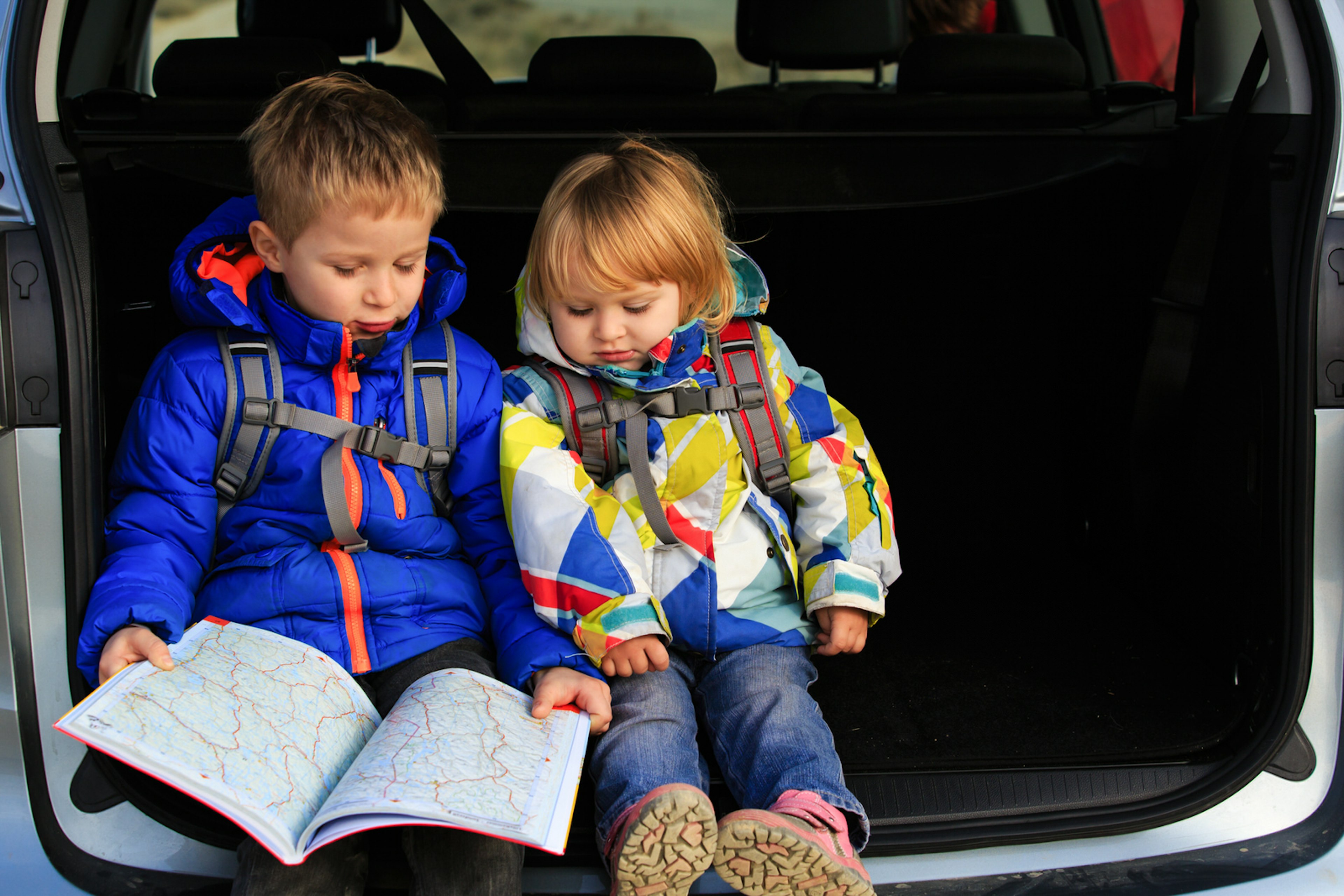 little boy and girl looking at map while travel by car; Shutterstock ID 376962181; Your name (First / Last): Emma Sparks; GL account no.: 61025; Netsuite department name: Online Editorial; Full Product or Project name including edition: Road trip with kids article