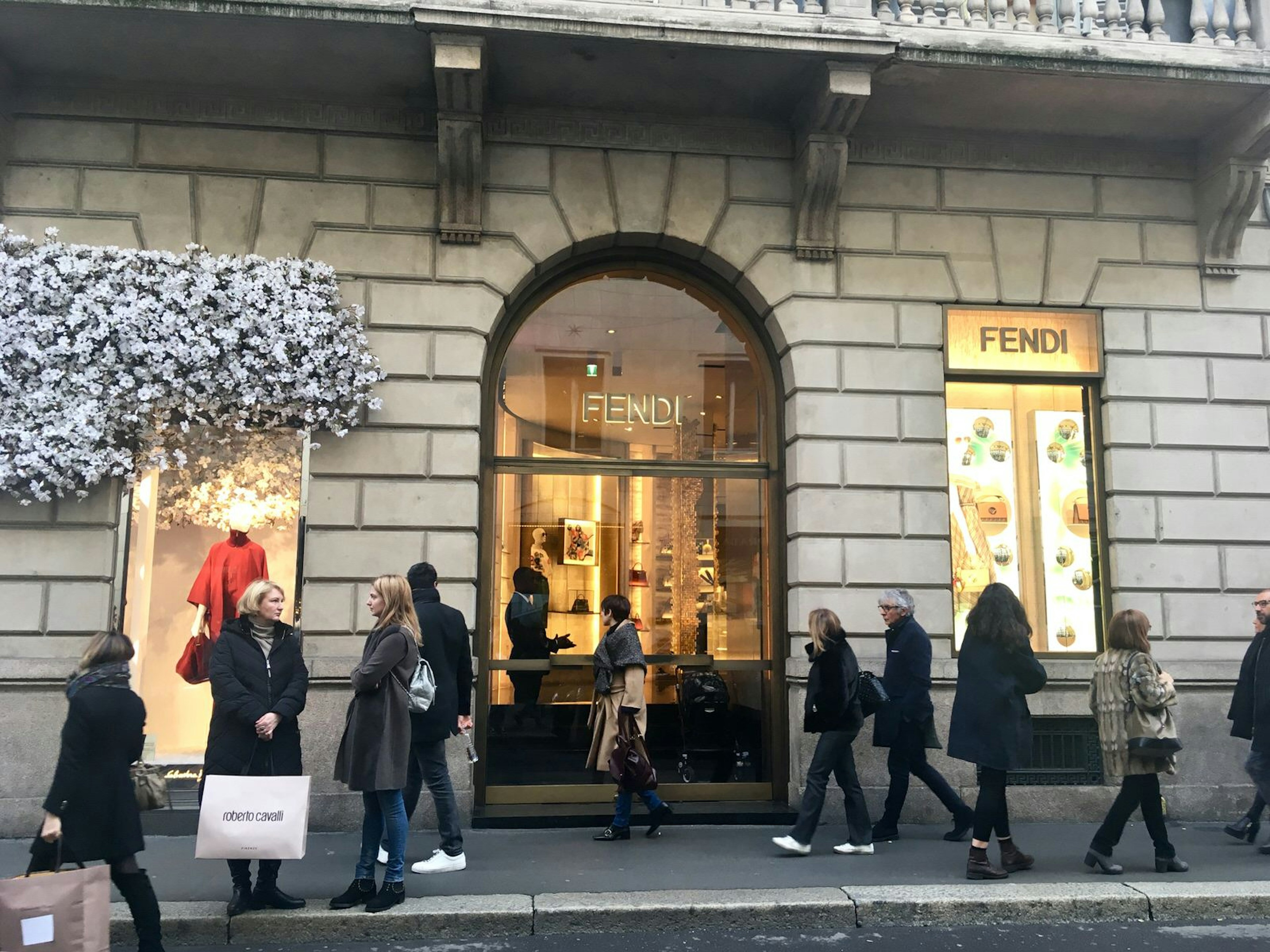 Stylish shoppers stroll past Milan's Fendi boutique