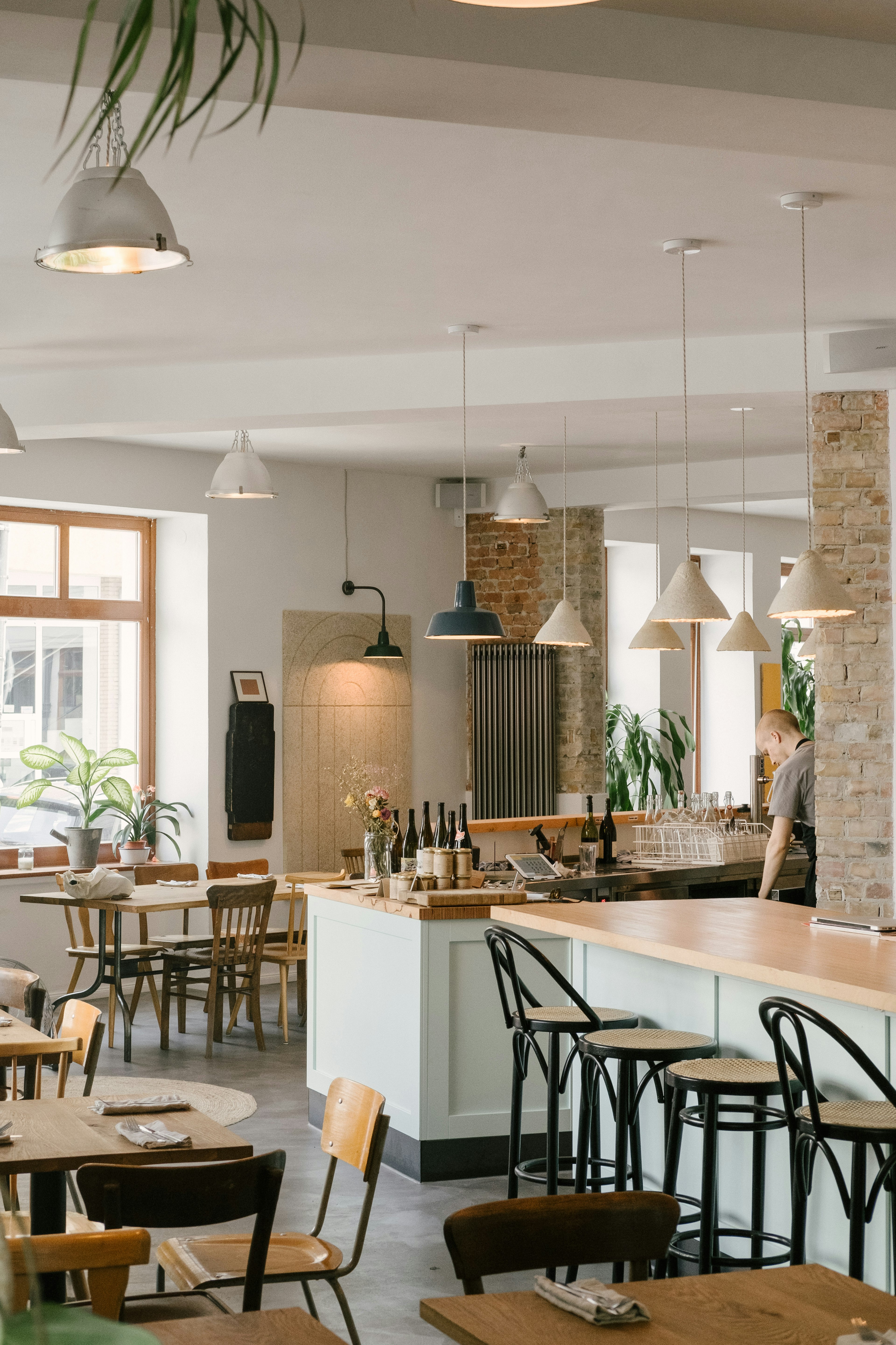 The bright interior of Frea restaurant in Berlin; there's exposed brickworks and the blond wood tables are paired with mismatched chairs.