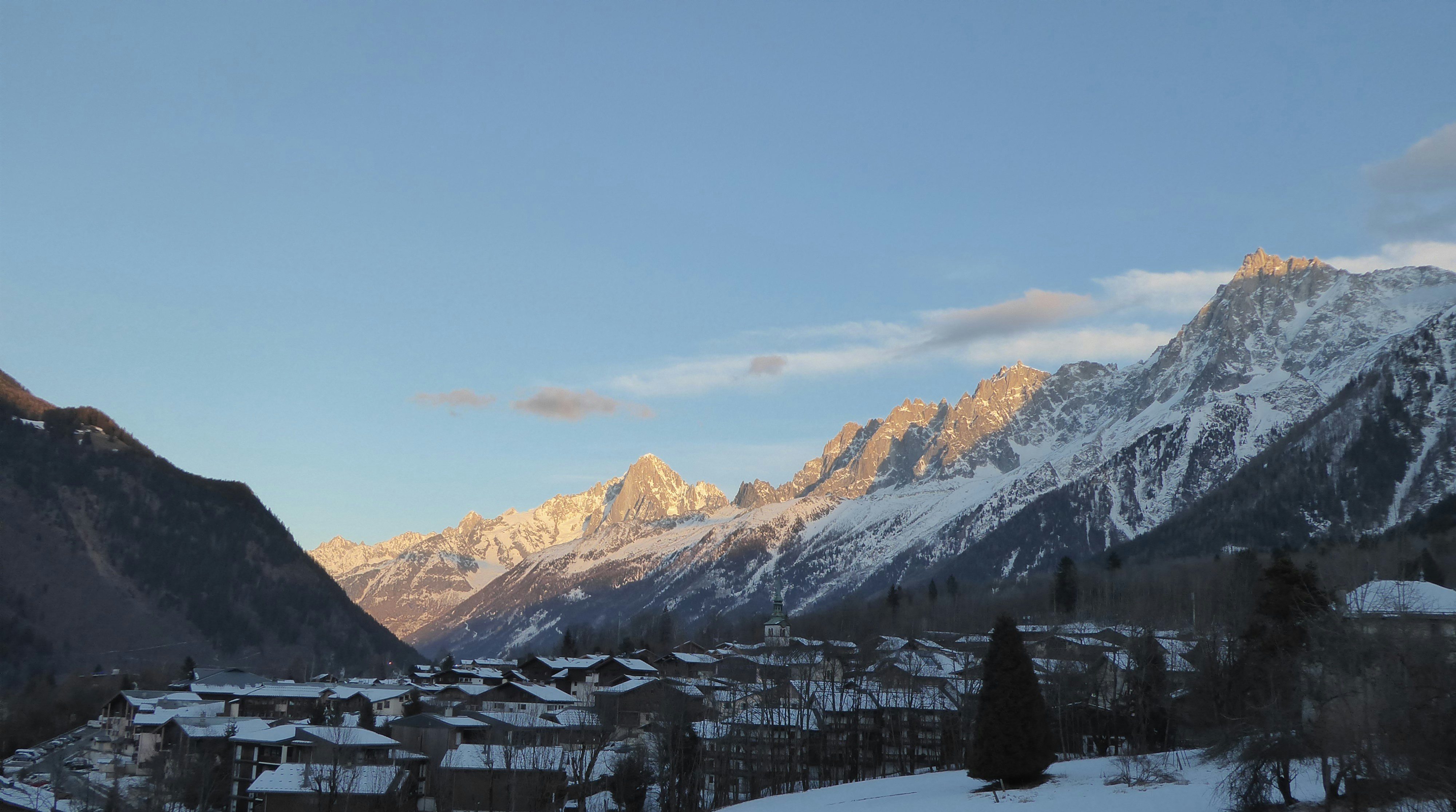 The peak of the mountains get the evening sun; they are golden but there is little snow at the top.