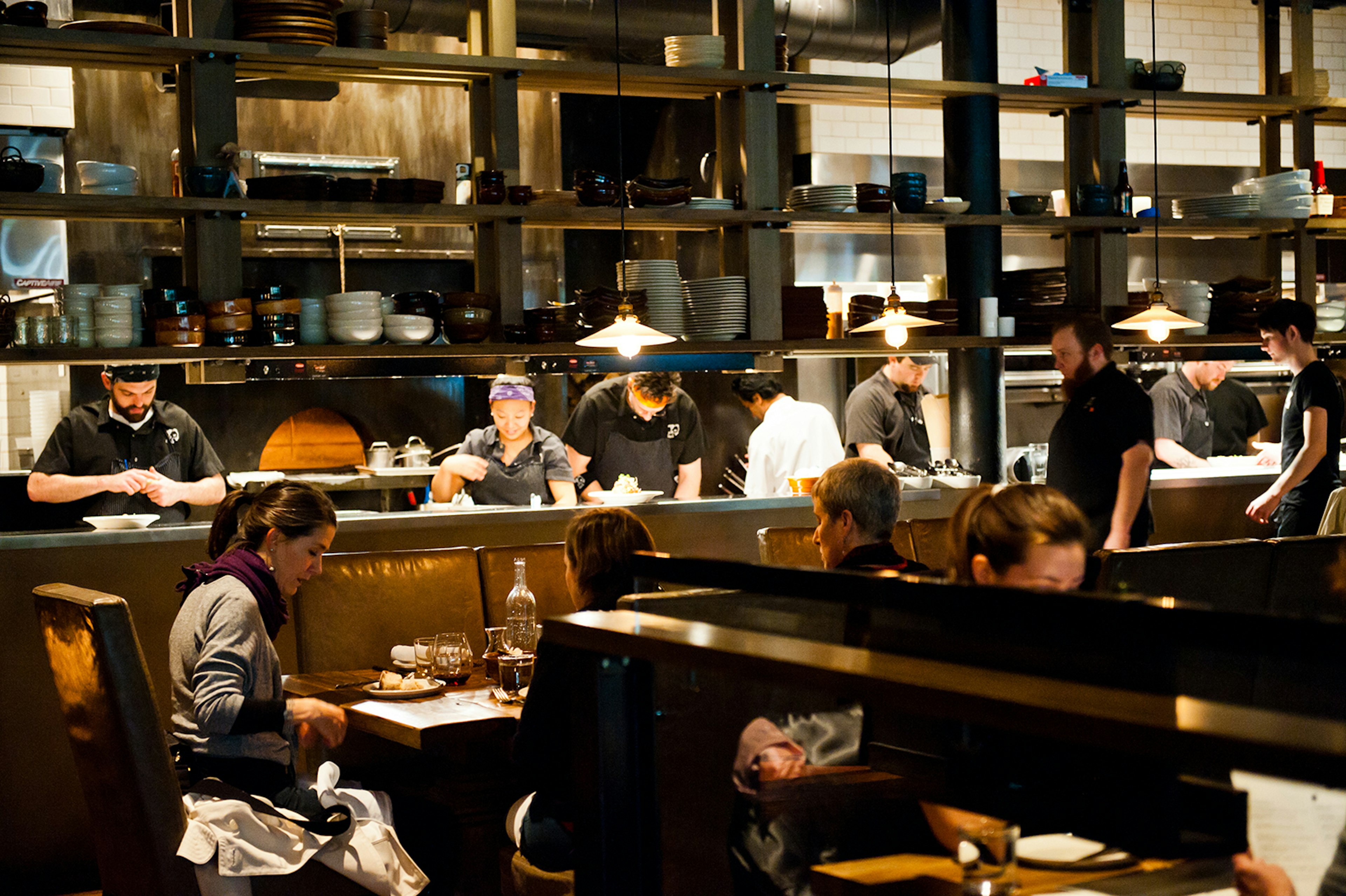 chefs work in an open kitchen at Girl & Goat, a stylish restaurant in Chicago