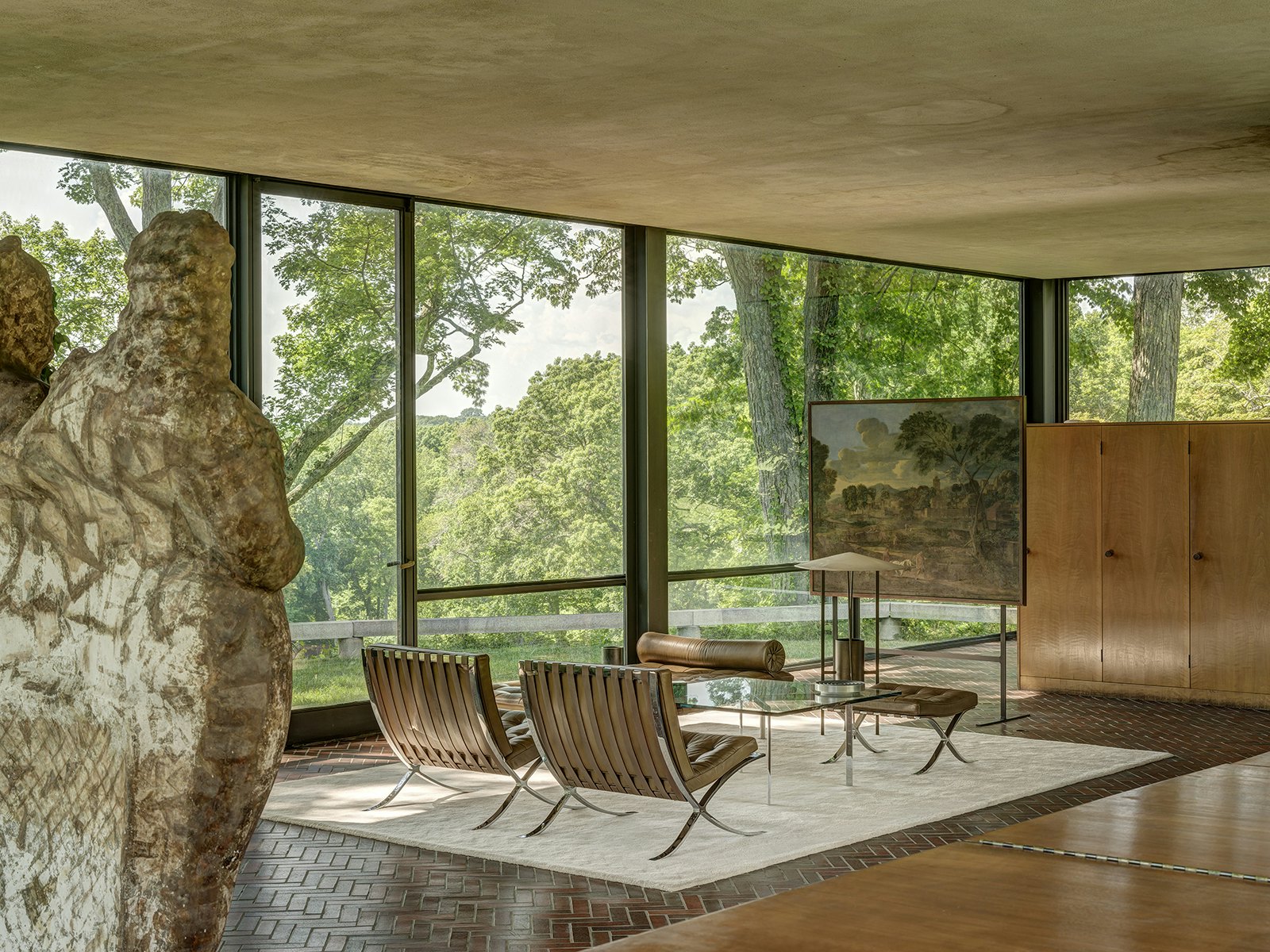 Wide interior shot of Glass House with mid-century modern furnishings on a white rug © Michael Biondo