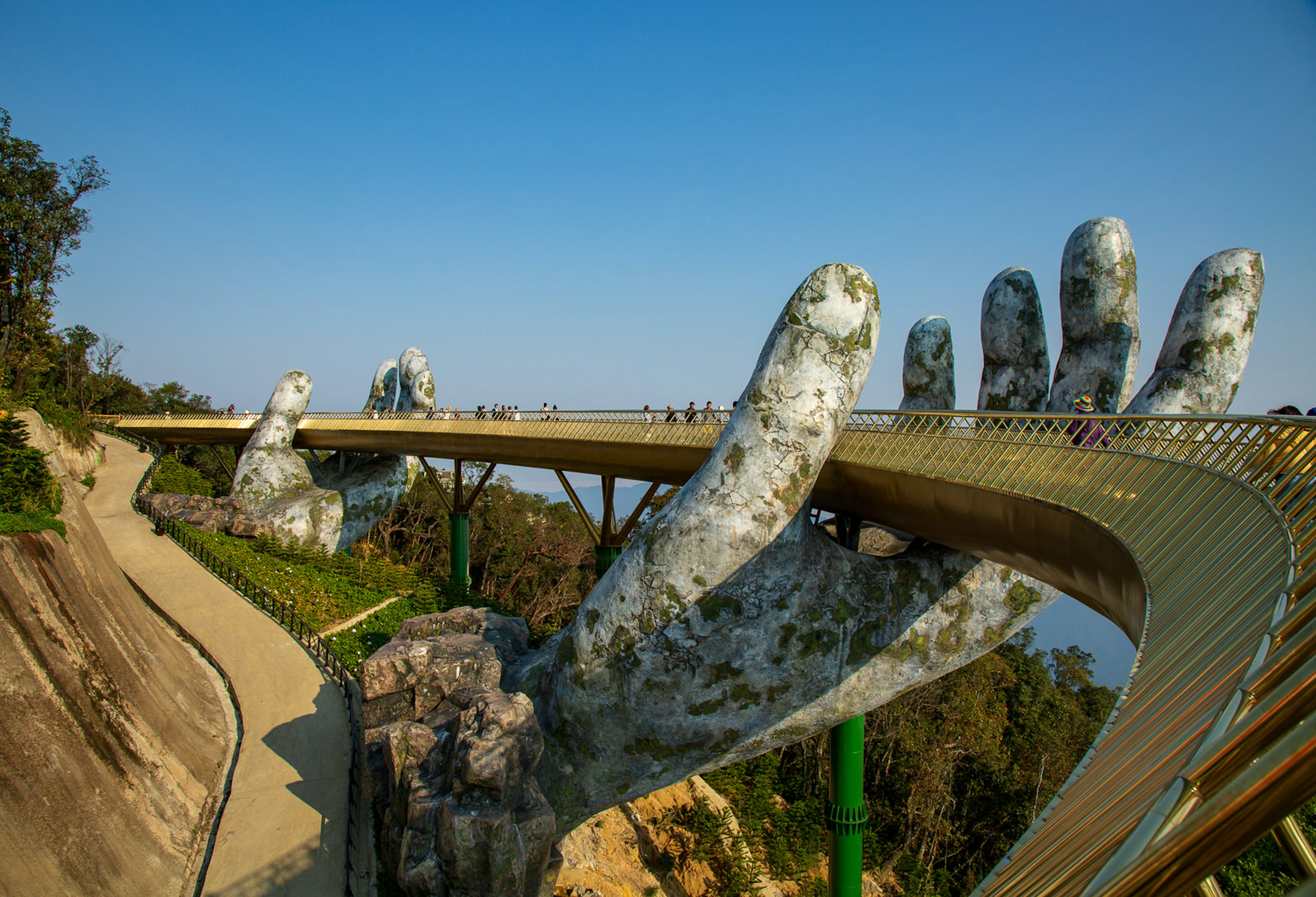 People stroll across the Golden Bridge in Ba Na Hills, which appears to be supported by giant hands