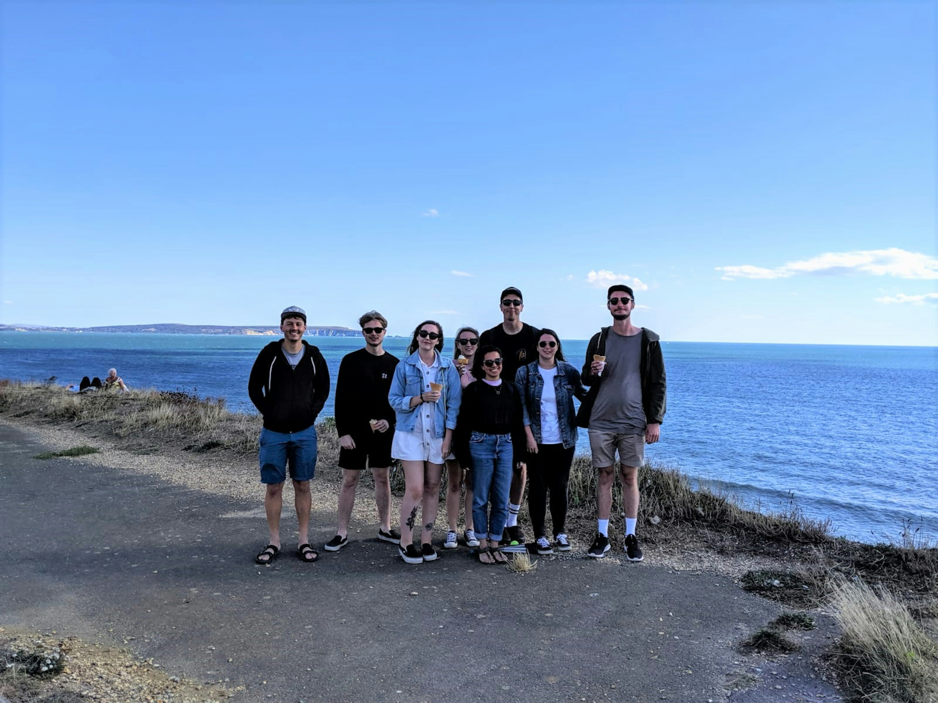 A group of 8 friends pose by the sea, some with ice-creams in hand; New Forest spending diary