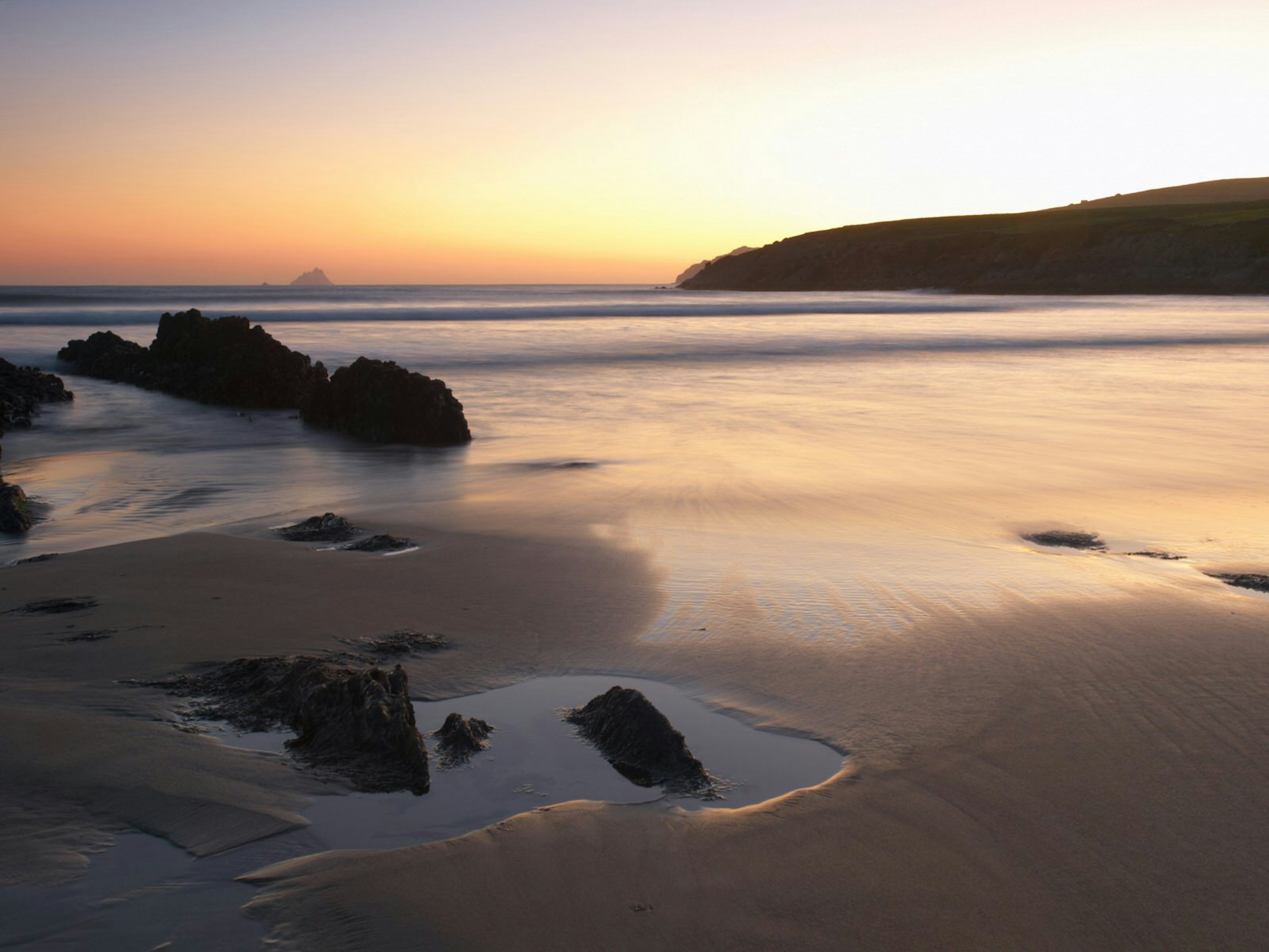 An empty beach in the orange colour of twilight