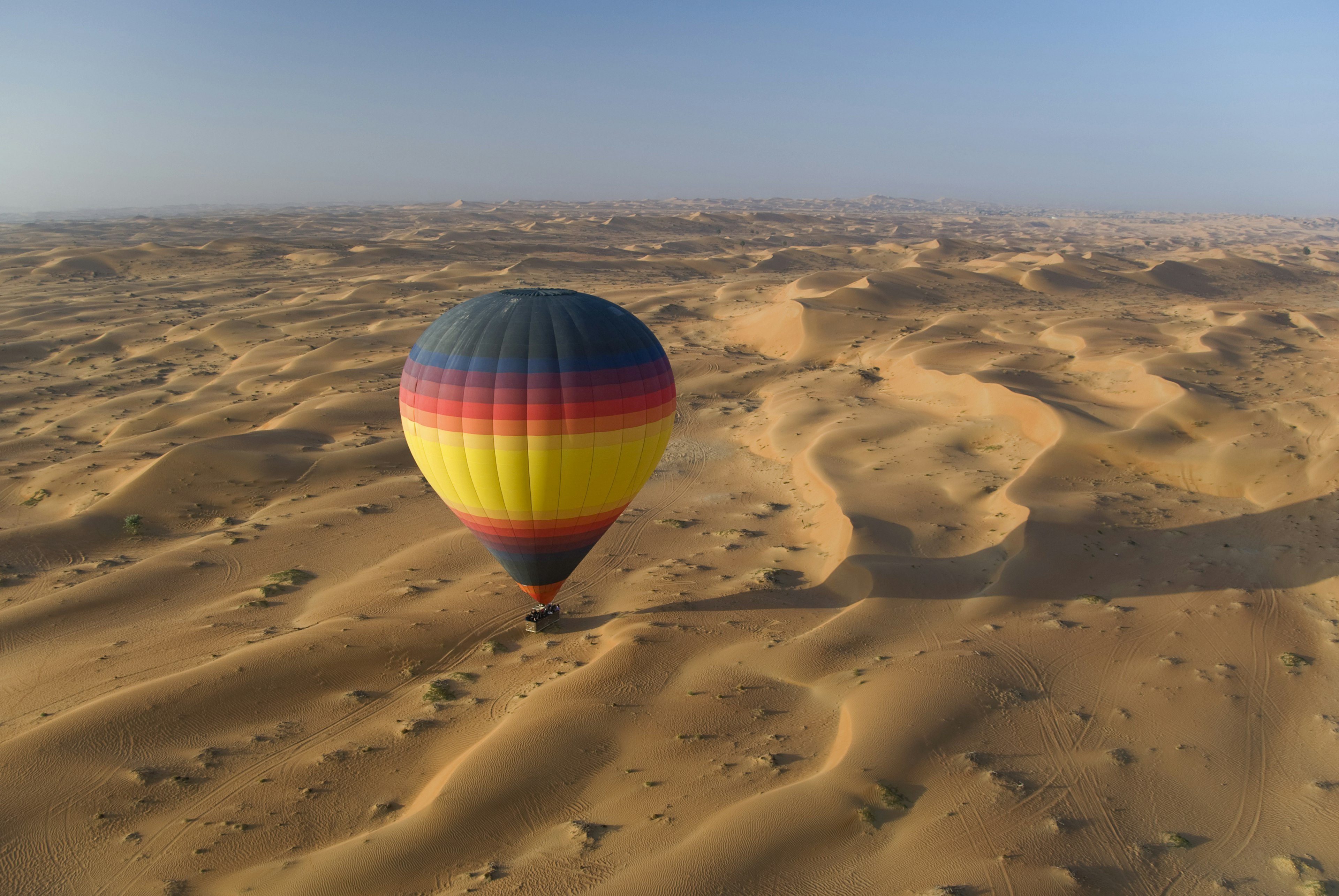 Hot-air balloon over the deserts of Dubai. Image by FrankvandenBergh / Getty