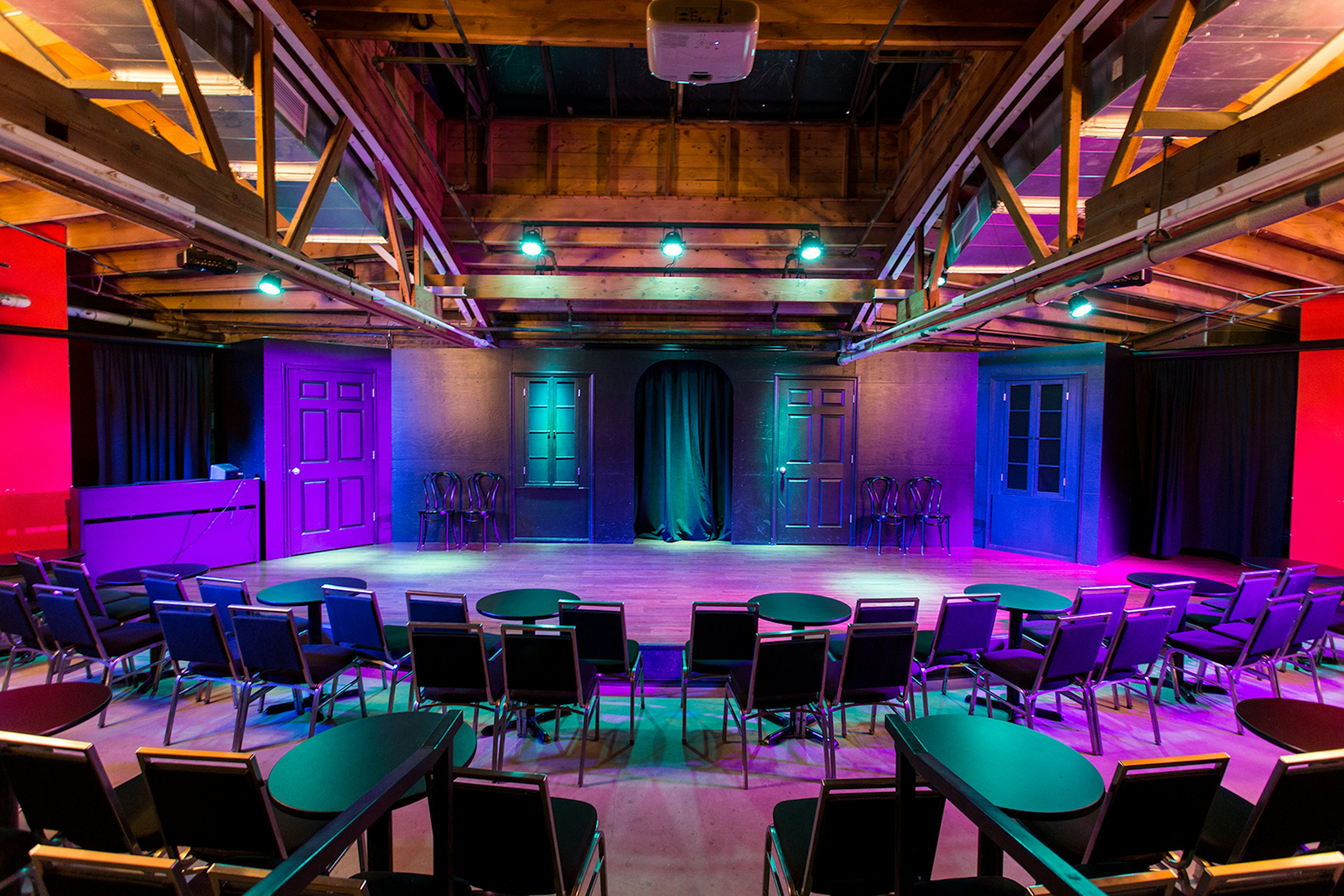 empty stage lit in blue, lavender and violet lights awaits an audience in Chicago