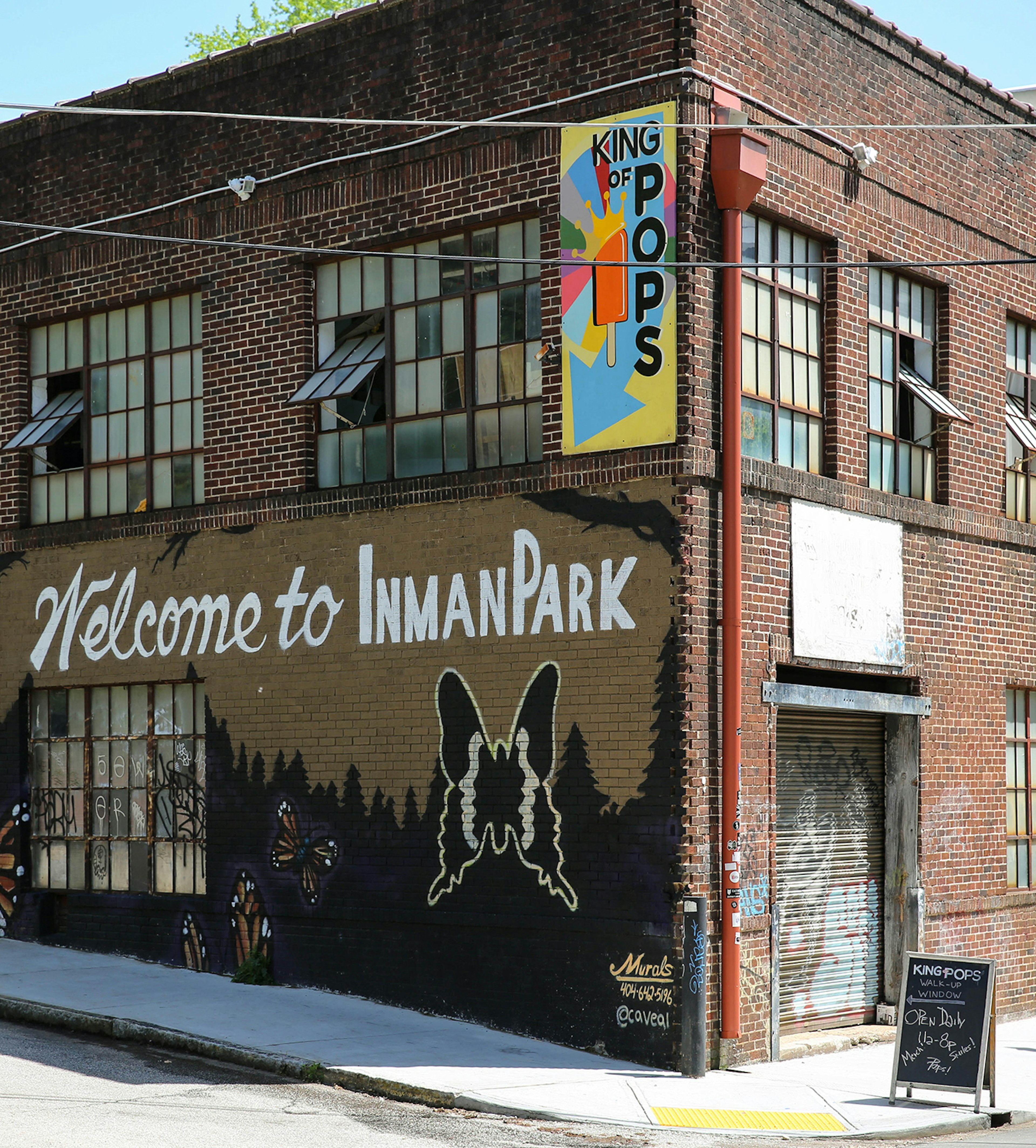 Exterior of King of Pops in Inman Park, with a mural on the side of a 19th-century, two-story brick building