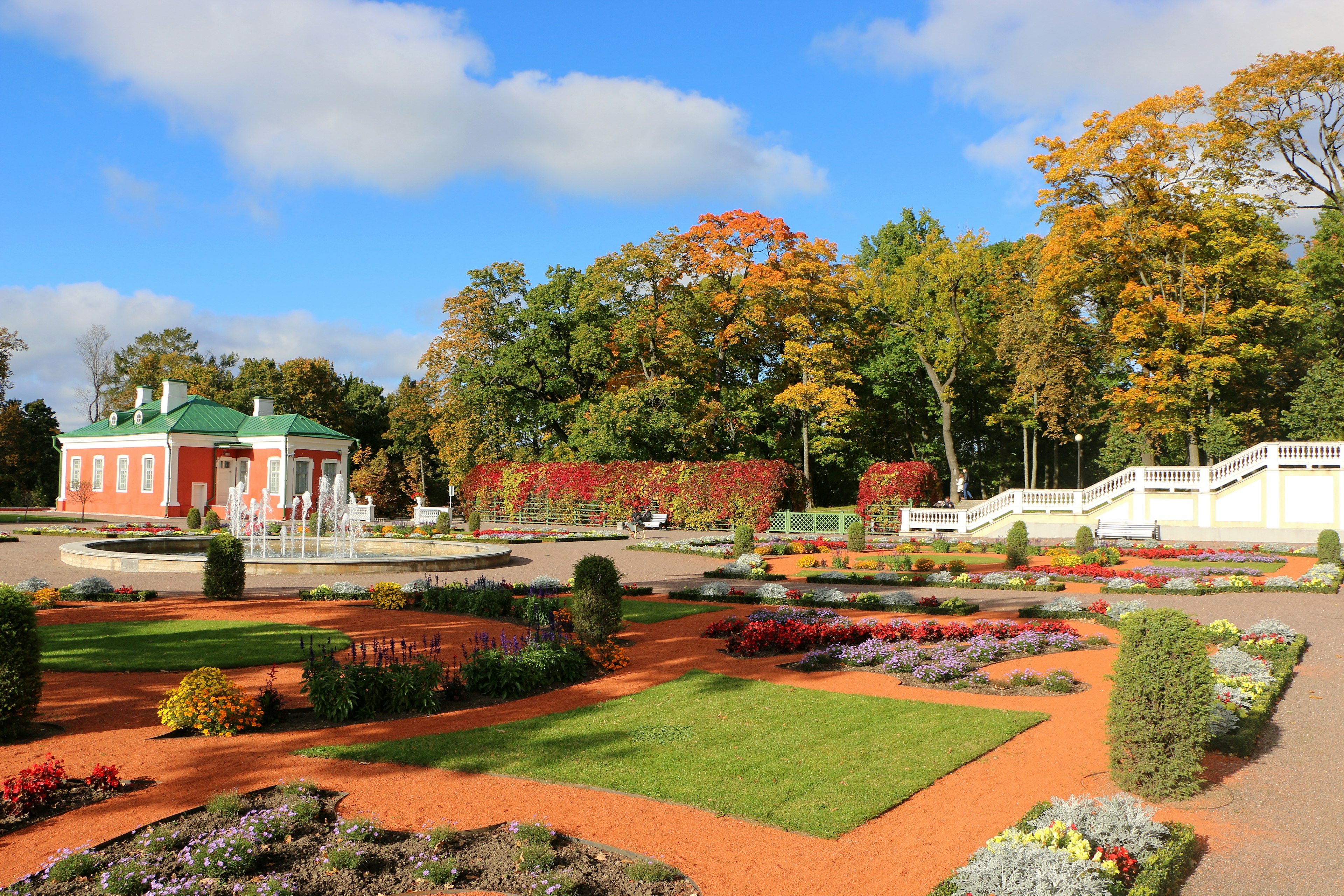 An autumn scene of yellow and orange trees surrounding a lake in Tallinn's Park Kadriorg