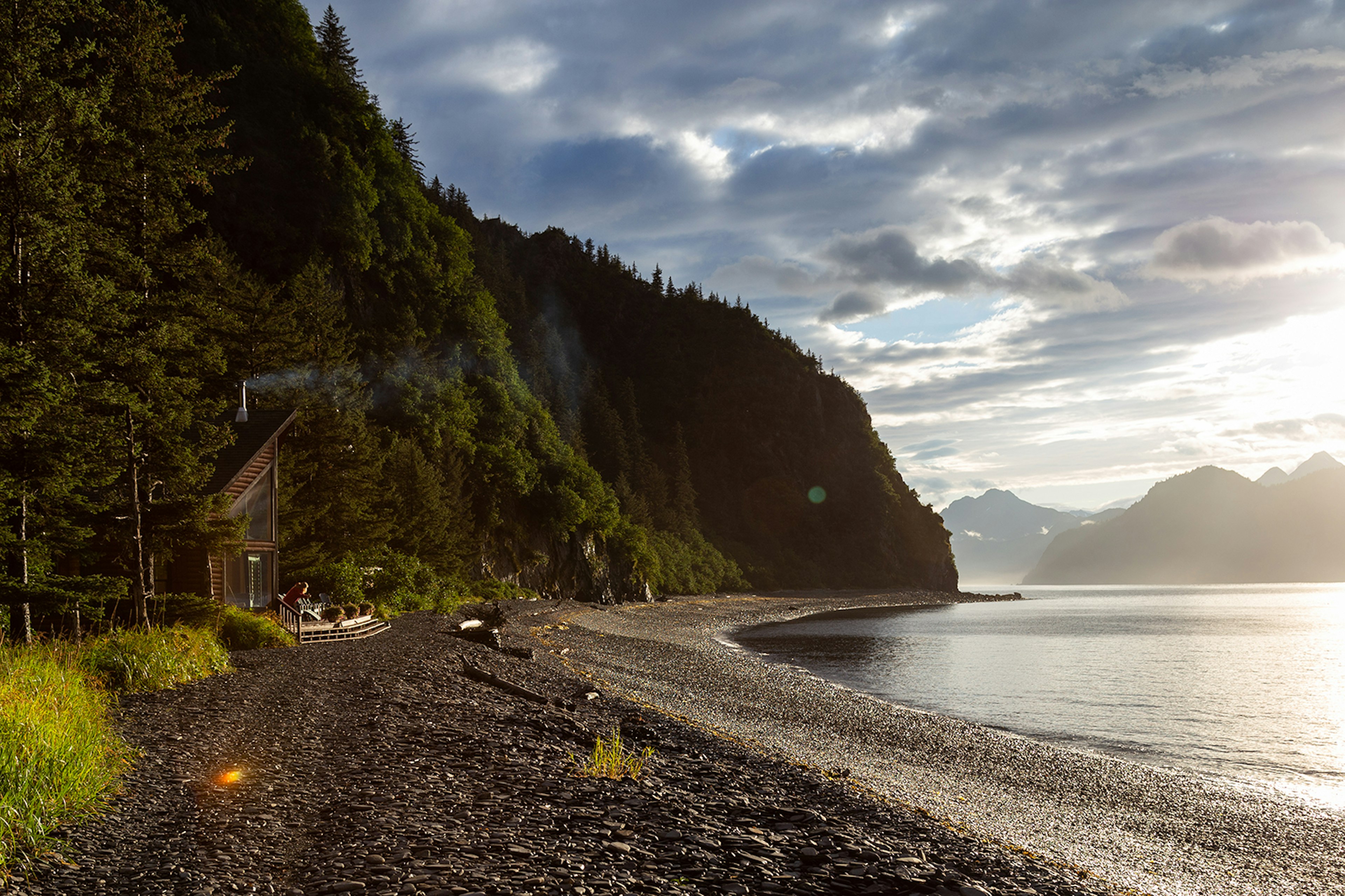 A rocky shoreline and a lodge near the water.