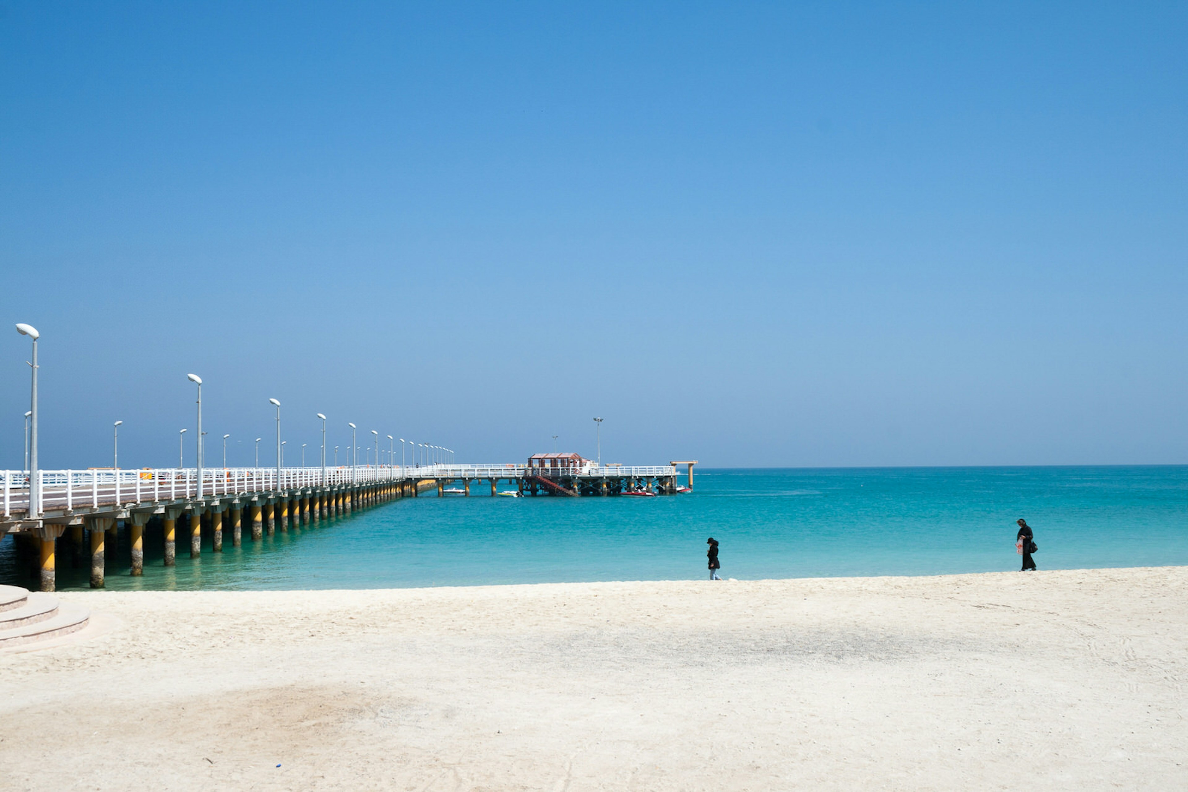 The Grand Recreational Pier of Kish Island, Iran, jutting from the sandy beach area into the azure-blue waters of the Gulf