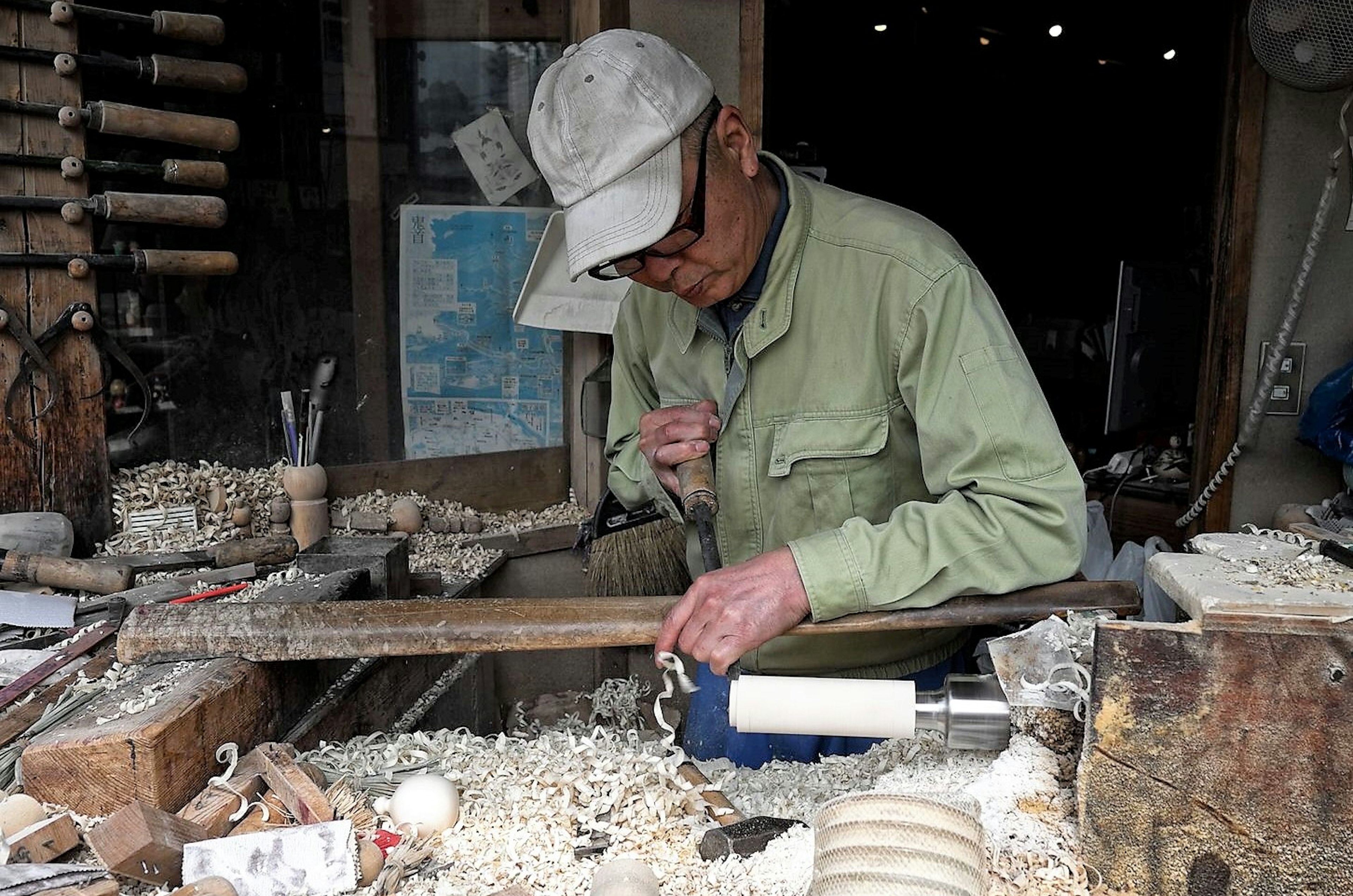 Artisan Yasuo Okazaki uses a lathe in his workshop to carve the basic shape of the kokeshi doll © Manami Okazaki / Lonely Planet