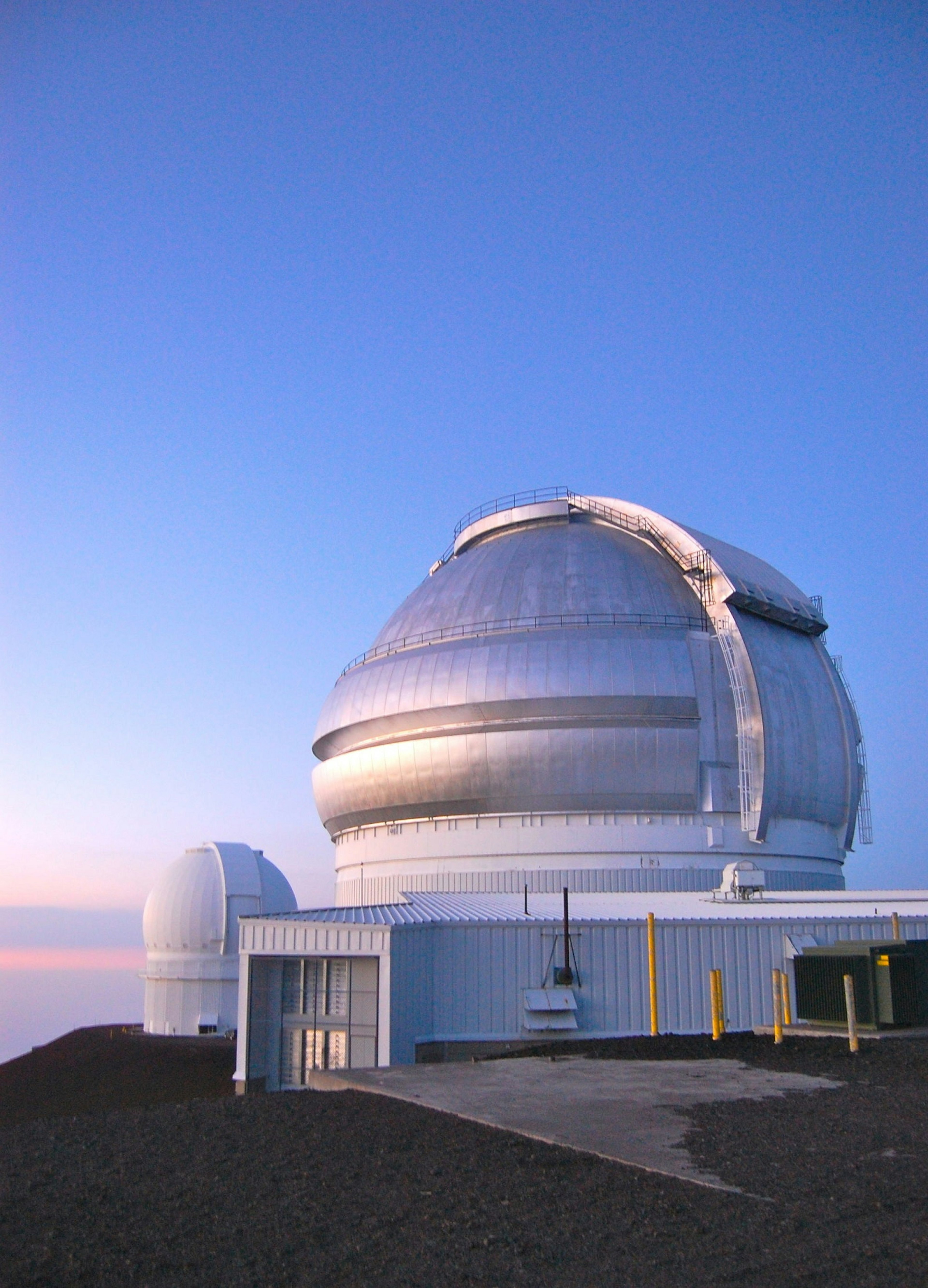 Two metal observatory domes in Mauna Kea, Hawaii, at dusk © lauraslens / Shutterstock